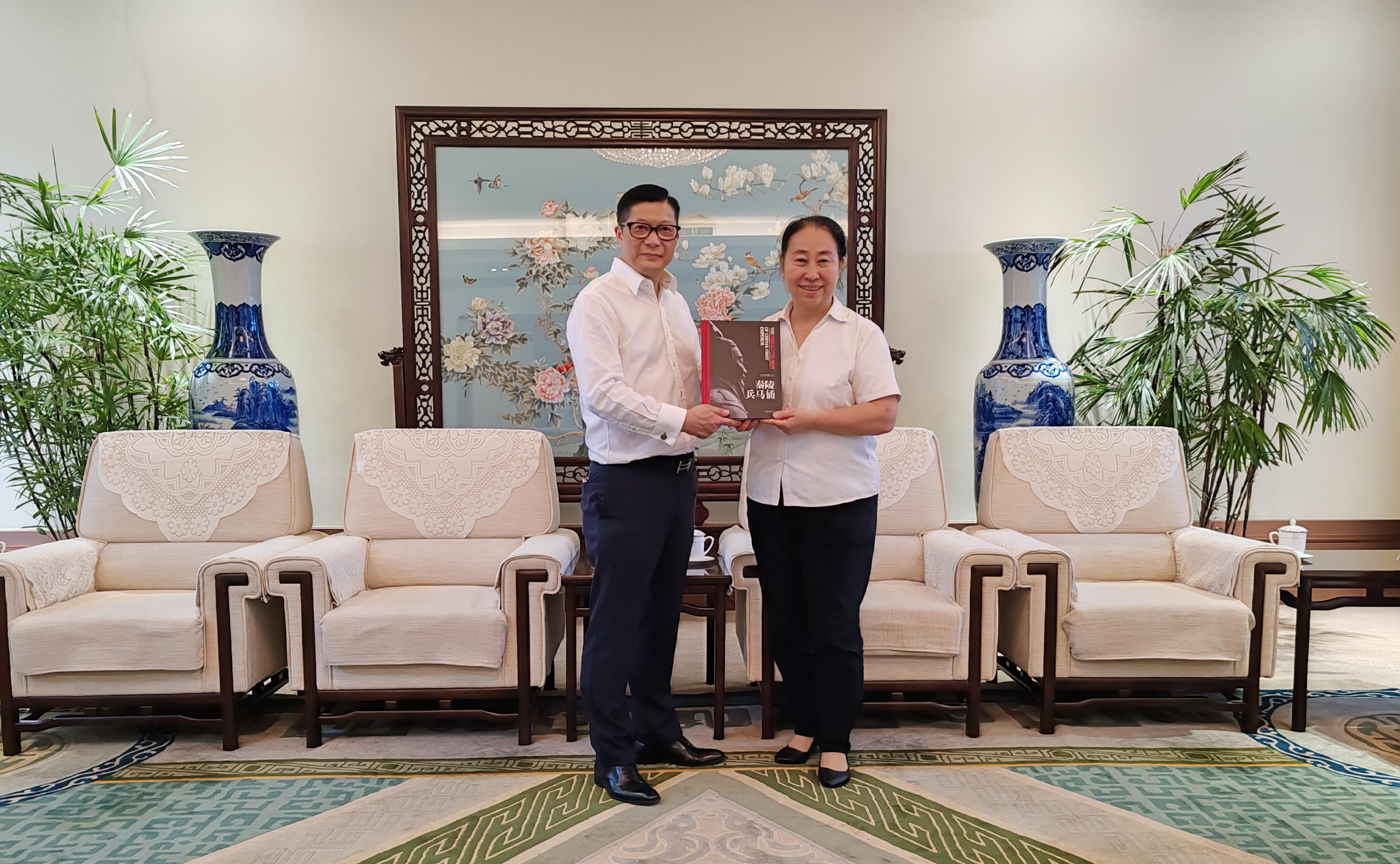 The Secretary for Security, Mr Tang Ping-keung, led members of the Security Bureau Youth Uniformed Group Leaders Forum and non-Chinese speaking students of Project Lighthouse to visit Shaanxi and Beijing. Photo shows Mr Tang (left) receiving a souvenir from Deputy Party Secretary and deputy curator of the Emperor Qinshihuang's Mausoleum Site Museum Ms Tian Jing (right) on August 14.