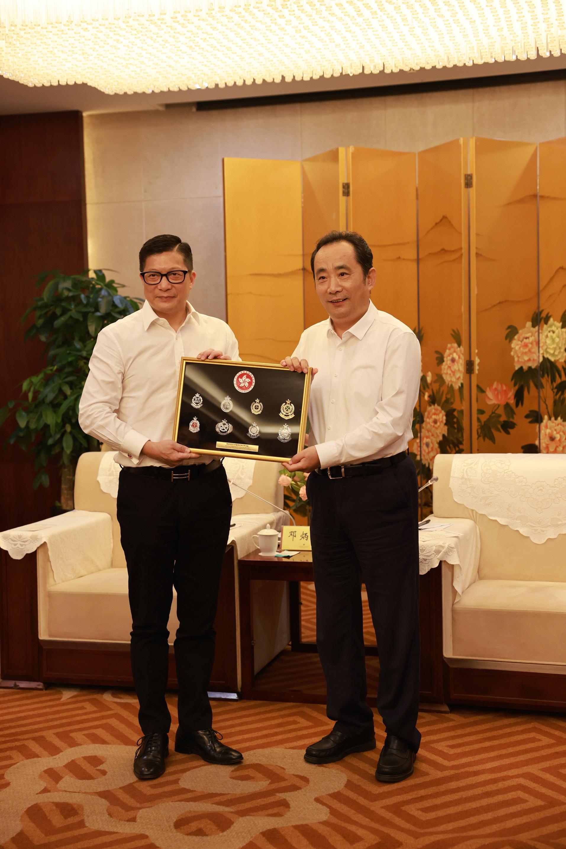 The Secretary for Security, Mr Tang Ping-keung, led members of the Security Bureau Youth Uniformed Group Leaders Forum and non-Chinese speaking students of Project Lighthouse to visit Shaanxi and Beijing. Photo shows Mr Tang (left) presenting a souvenir to Standing Committee Member and Head of the United Front Work Department of the CPC Shaanxi Provincial Committee, Mr Li Mingyuan (right), on August 15.