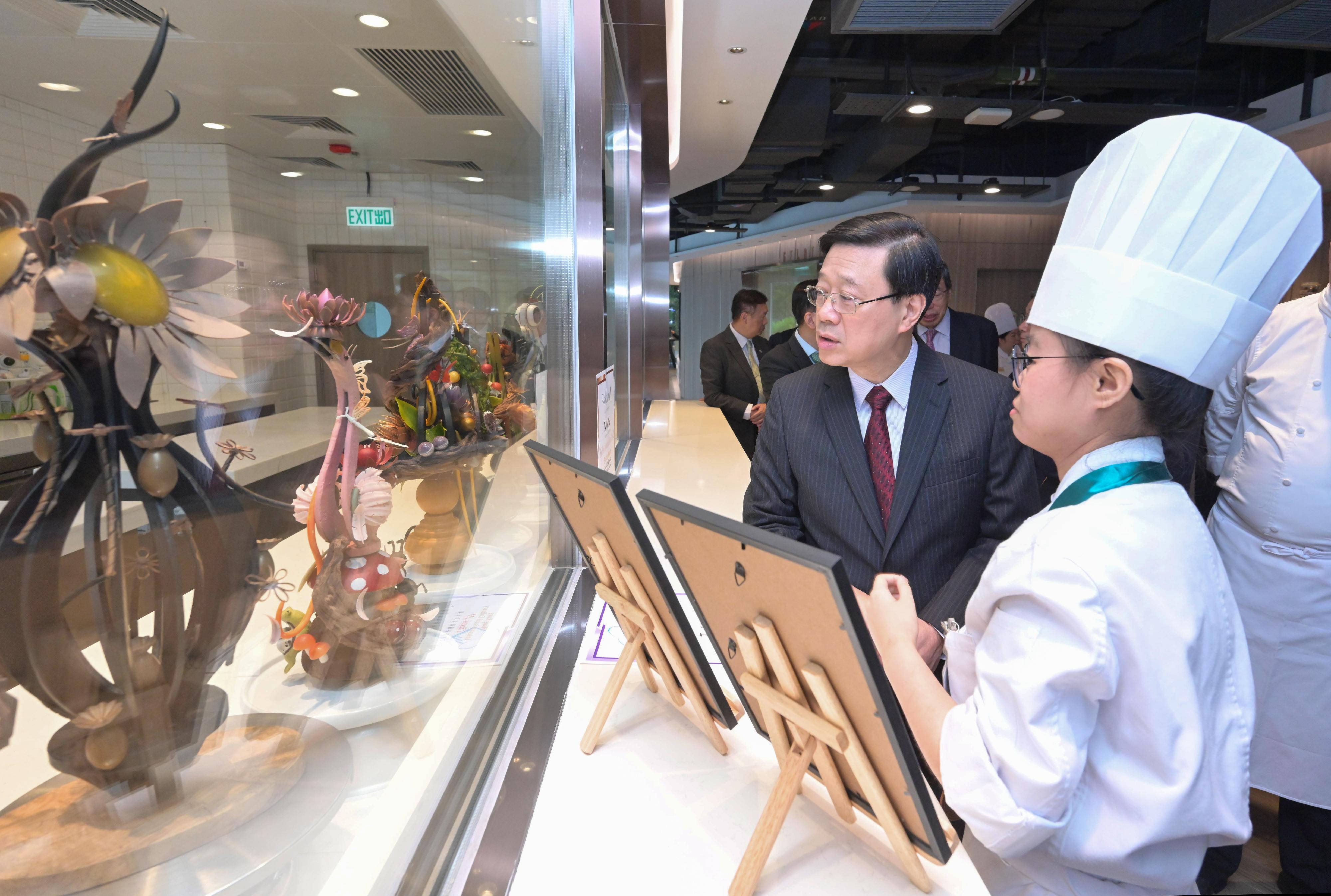 The Chief Executive, Mr John Lee, today (August 17) visited the International Culinary Institute of the Vocational Training Council. Photo shows Mr Li (second right) viewing chocolate and sugar arts created by students. 