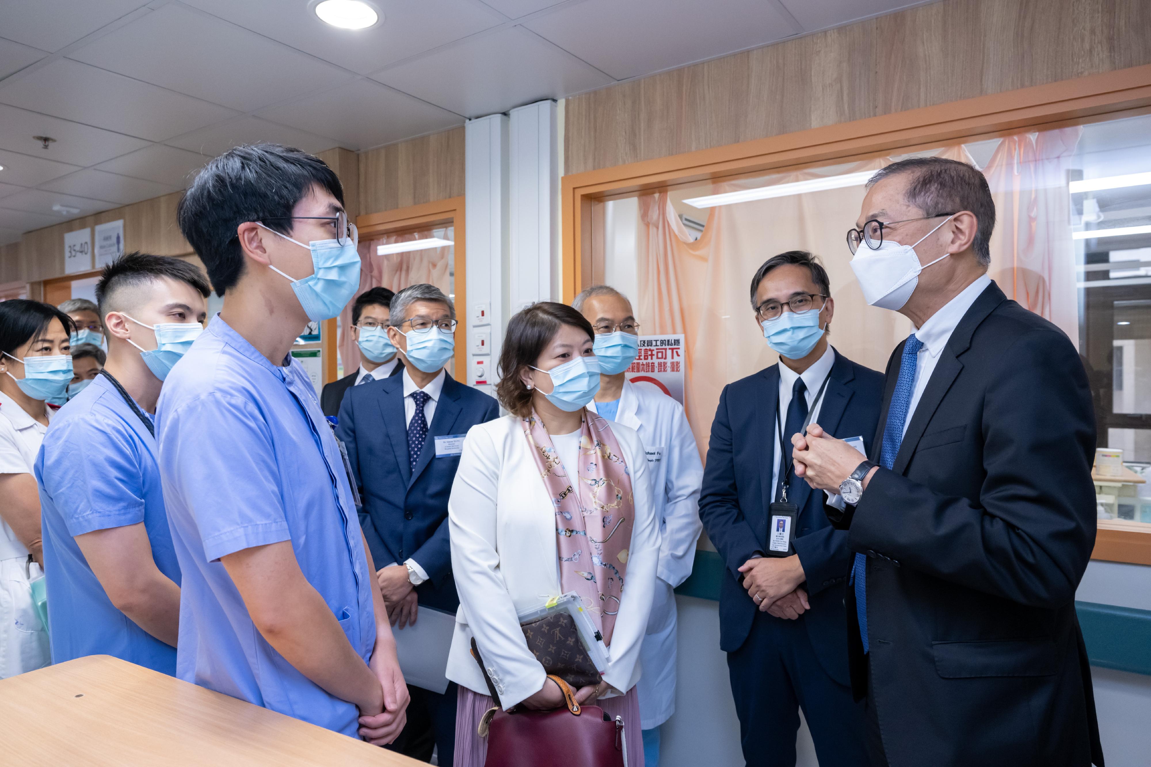 The Secretary for Health, Professor Lo Chung-mau, visited Tuen Mun Hospital (TMH) this afternoon (August 17). Photo shows Professor Lo (first right) and the Under Secretary for Health, Dr Libby Lee (fourth right), chatting with the healthcare personnel of TMH.