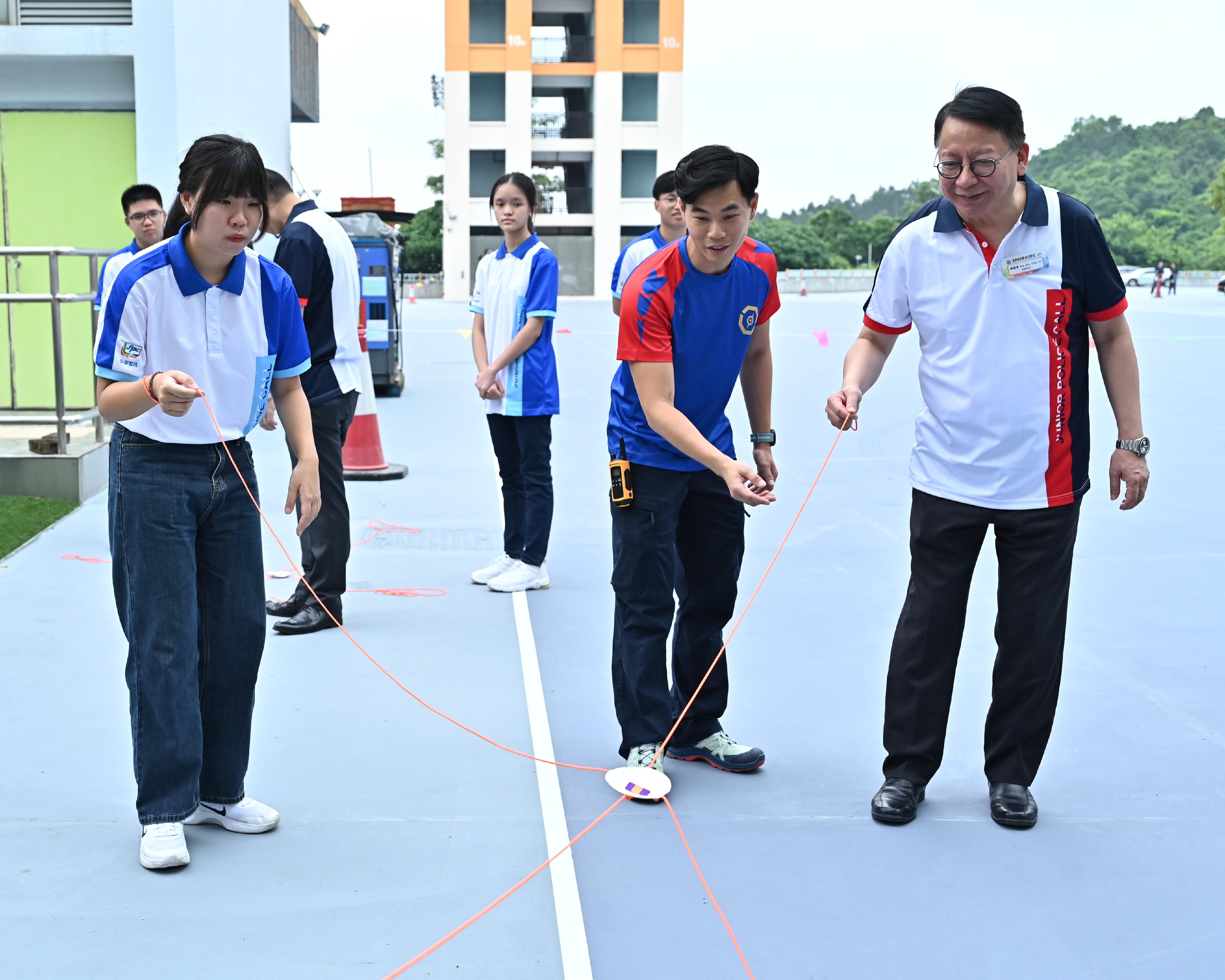 The Opening Ceremony of Junior Police Call (JPC) Summer Camp 2023 was held today (August 17). Photo shows the Chief Secretary for Administration, Mr Chan Kwok-ki (first right) co-operating with participants in the team building game.