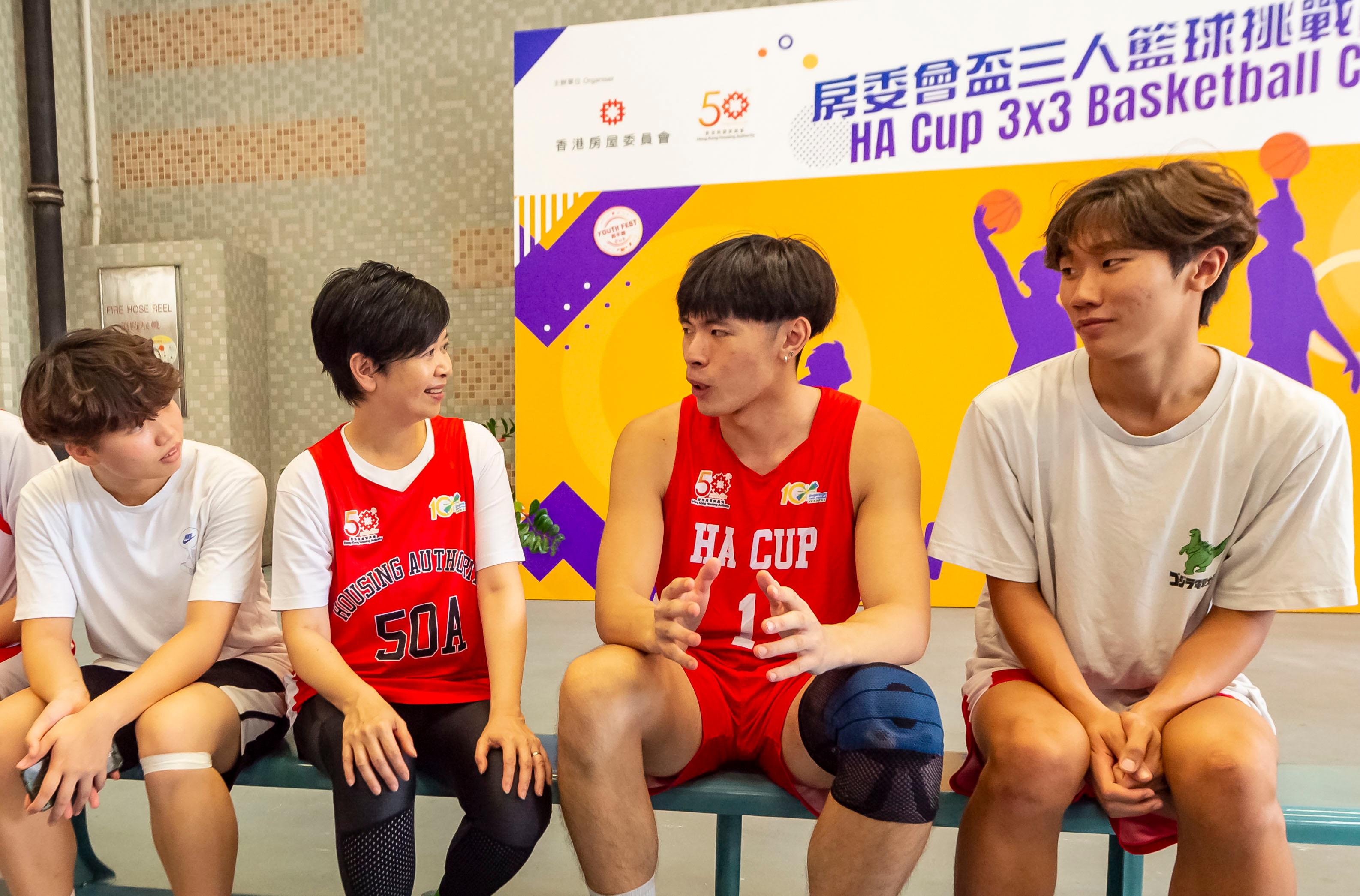 香港房屋委員為慶祝成立50周年而舉辦的「房委會盃三人籃球挑戰賽」今日（八月二十日）進行決賽。圖示房屋局局長何永賢（左二）與年青球員交談。