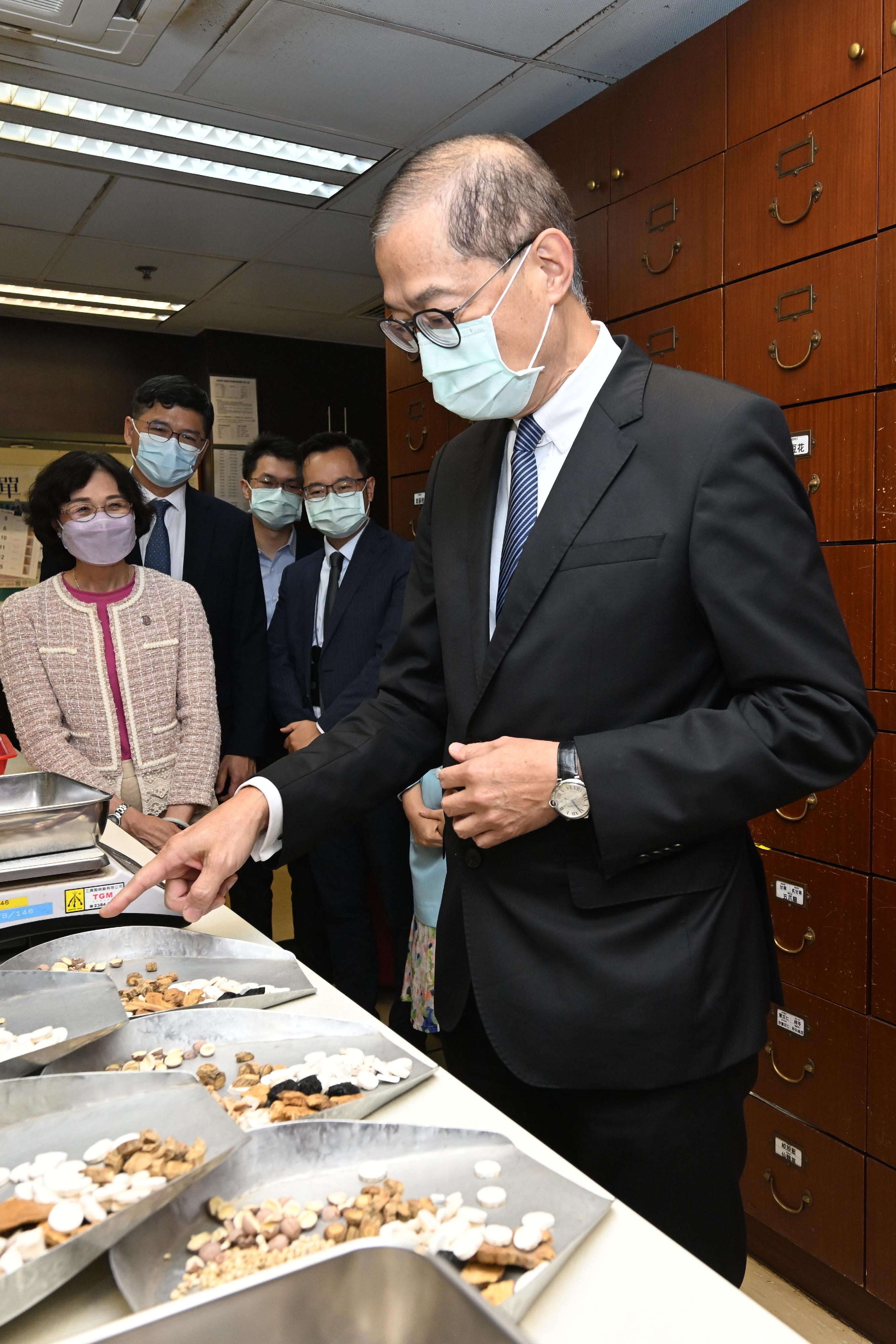 The Secretary for Health, Professor Lo Chung-mau (first right), visits the Chinese Medicine Clinic cum Training and Research Centre in Kwai Tsing District today (August 29) and tours its Chinese medicine dispensary.