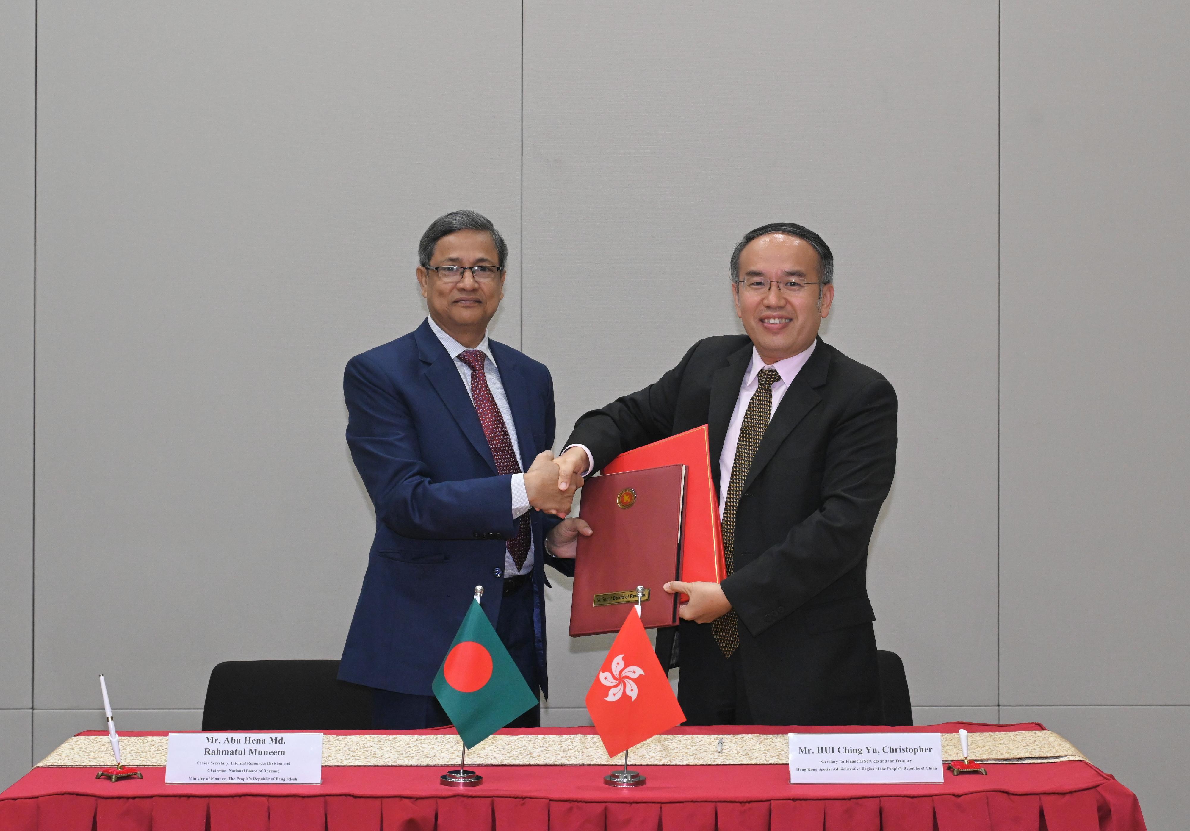 The Secretary for Financial Services and the Treasury, Mr Christopher Hui (right), exchanges documents with the Senior Secretary of the Internal Resources Division and Chairman of the National Board of Revenue of the Ministry of Finance of Bangladesh, Mr Abu Hena Md. Rahmatul Muneem (left), after signing a comprehensive avoidance of double taxation agreement today (August 30).