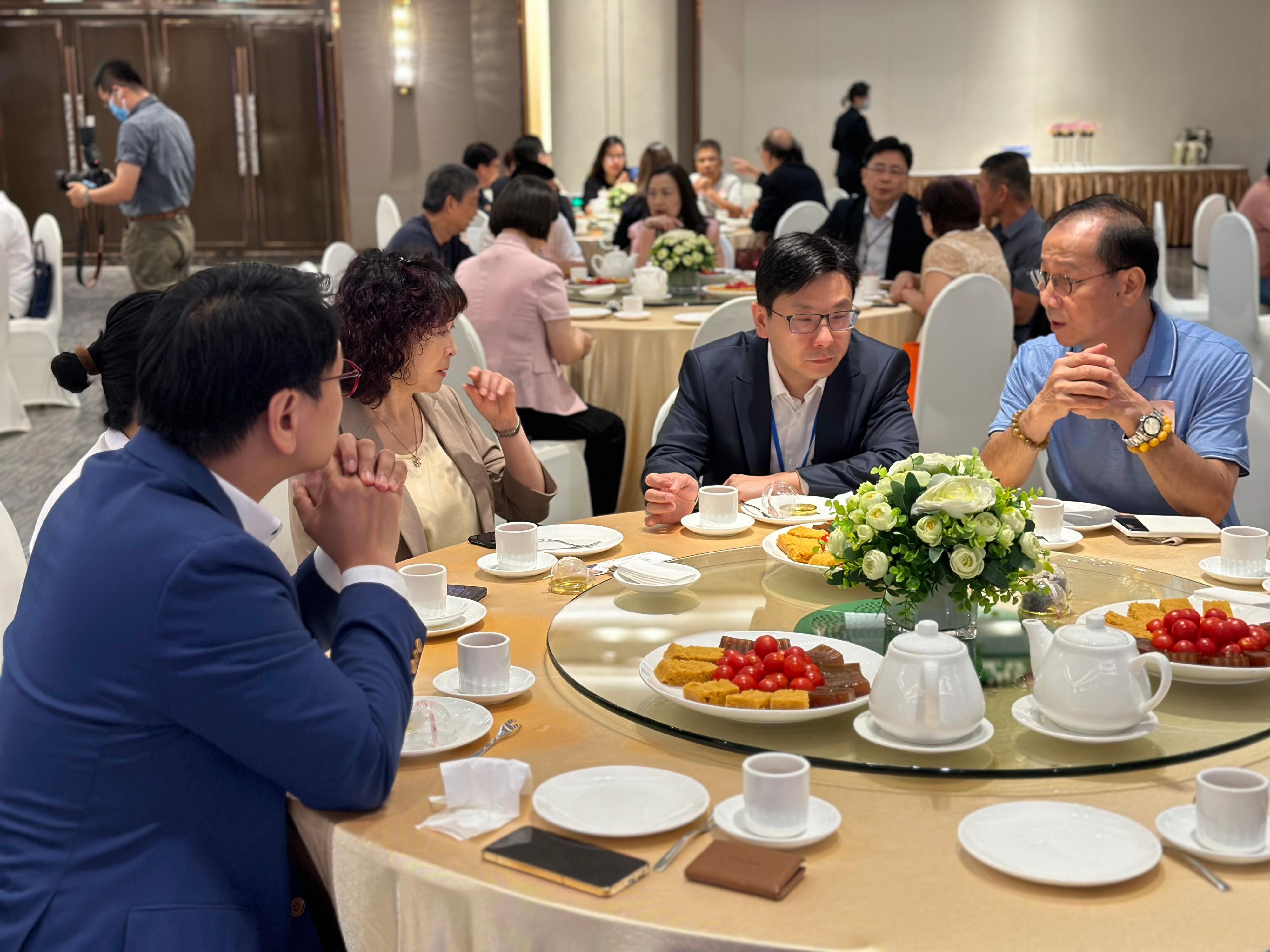 The Secretary for Labour and Welfare, Mr Chris Sun, leading a delegation of the Labour and Welfare Bureau, today (August 30) started his visit to three Mainland cities in the Guangdong-Hong Kong-Macao Greater Bay Area, together with a delegation of the Legislative Council Panel on Welfare Services. Photo shows Mr Sun (second right), accompanied by the Vice Chairman of Clifford Group, Ms Wendy Man (third right), in Guangzhou this morning, listening to a retired Hong Kong resident in Clifford Estates sharing his retirement life and needs on the Mainland.