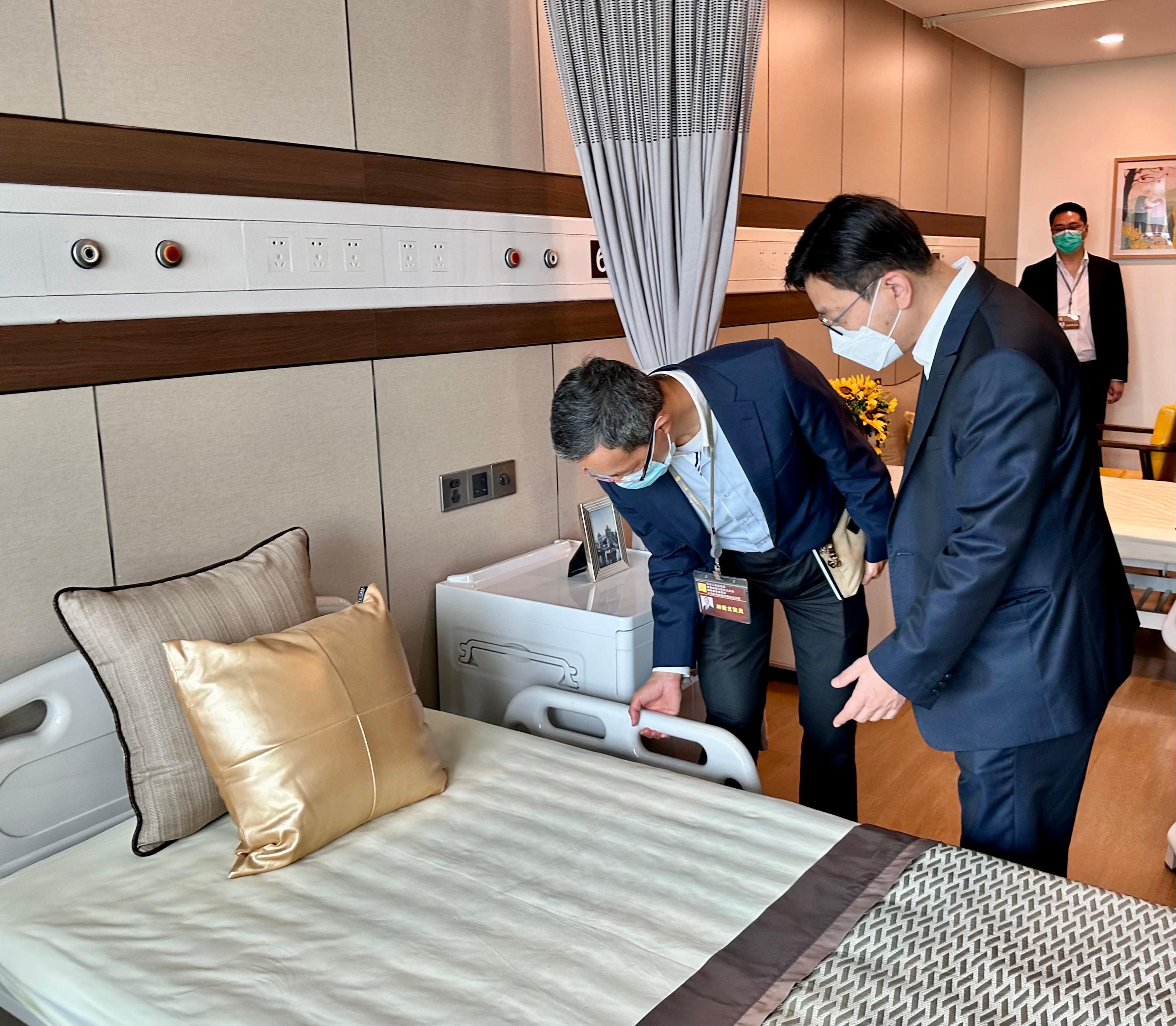 The Secretary for Labour and Welfare, Mr Chris Sun, leading a delegation of the Labour and Welfare Bureau, today (August 30) started his visit to three Mainland cities in the Guangdong-Hong Kong-Macao Greater Bay Area, together with a delegation of the Legislative Council Panel on Welfare Services. Photo shows Mr Sun (right) taking a closer look at a residential care place for the elderly in the Clifford Care Center while in Guangzhou this afternoon.