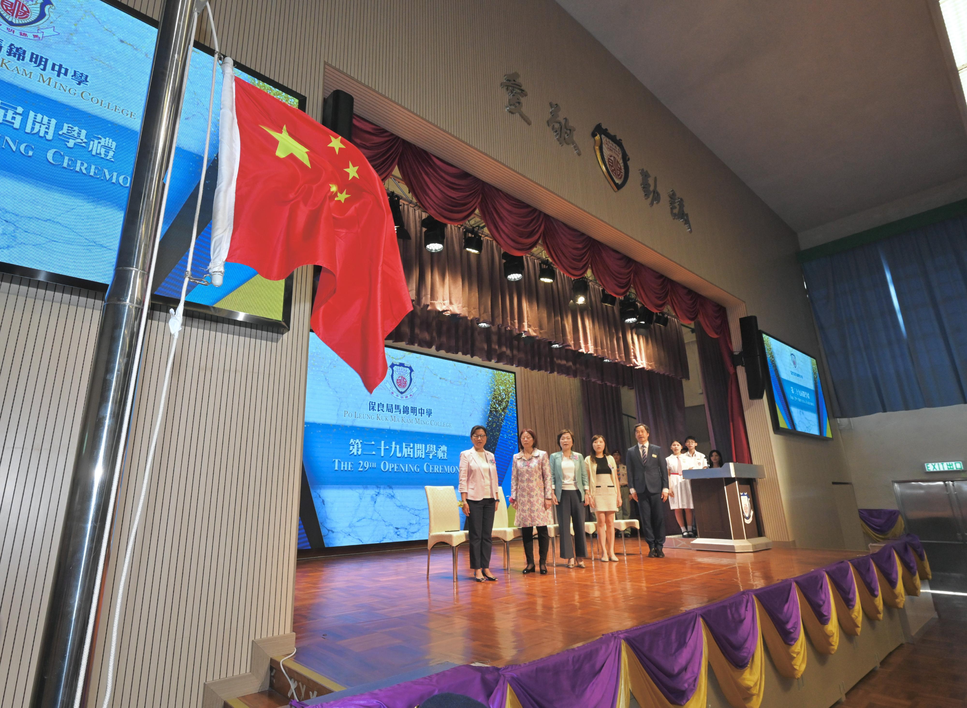 The Secretary for Education, Dr Choi Yuk-lin, visited Po Leung Kuk Ma Kam Ming College on the first school day today (September 4). Photo shows Dr Choi (third left) singing the national anthem and viewing the raising of the national flag at the school opening ceremony.
