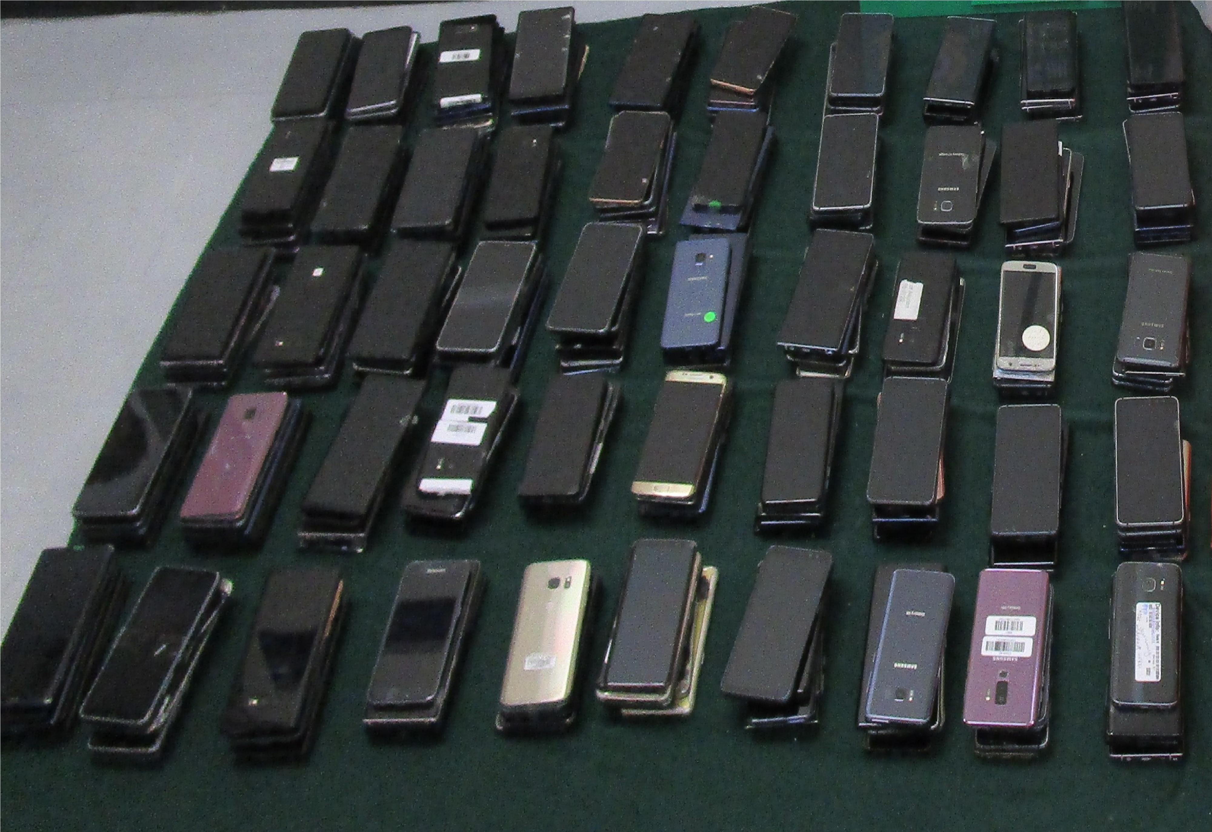自八月一日起，香港海關聯同警方在落馬洲支線管制站對出境人士加強執法行動。圖示部分檢獲的舊手提電話。