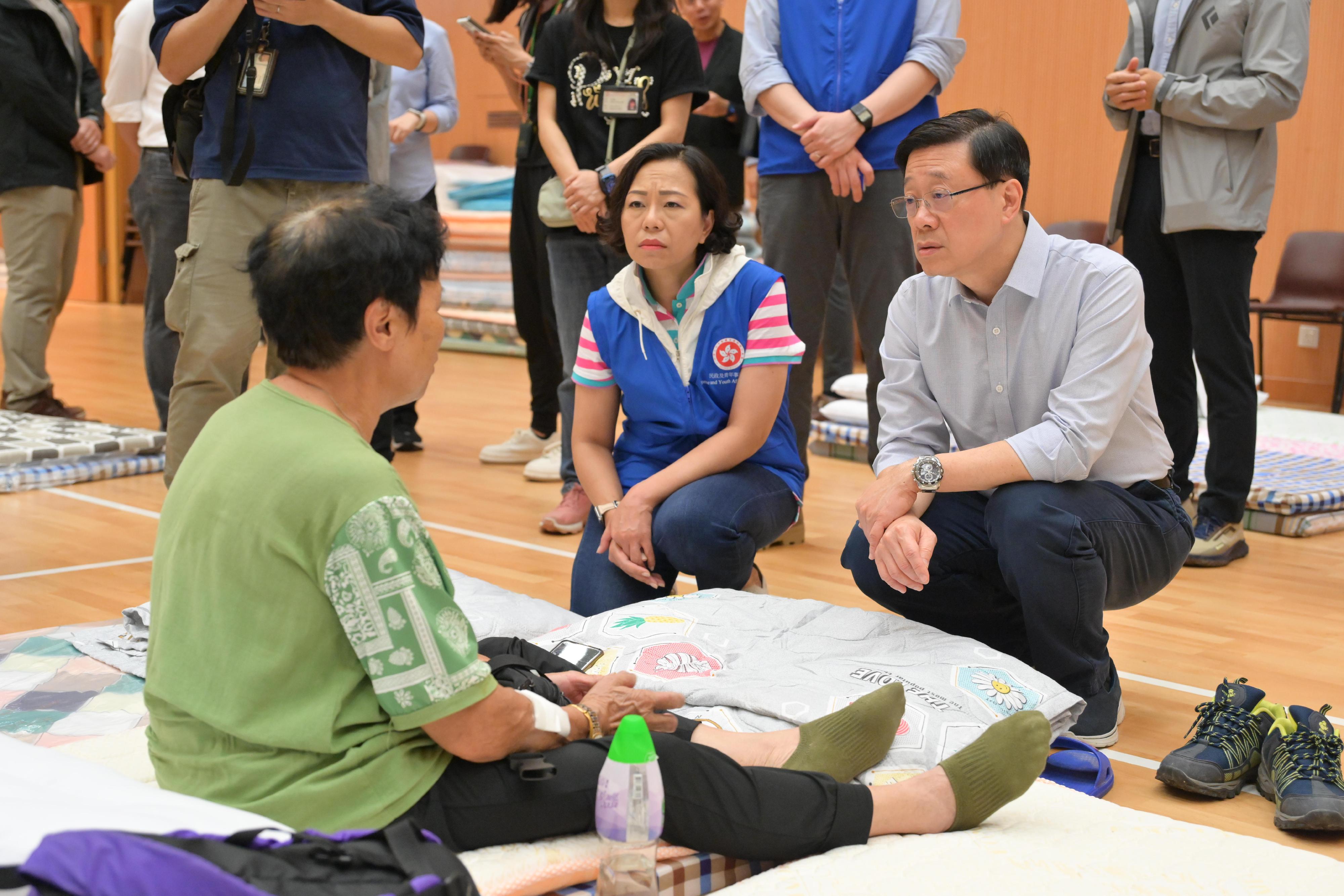 The Chief Executive, Mr John Lee, inspected the relief work in the wake of the torrential rain in Fanling today (September 9). Photo shows Mr Lee (first right), accompanied by the Secretary for Home and Youth Affairs, Miss Alice Mak (second right), visiting members of the public affected by the torrential rain at the temporary shelter in Luen Wo Hui Community Hall.