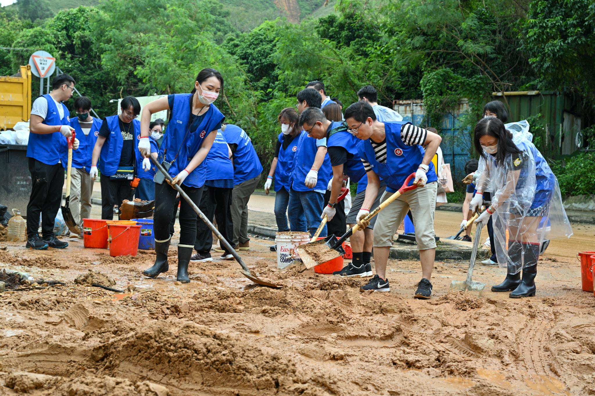 The Chief Executive, Mr John Lee, announced the activation of the mobilisation protocol for civil servants to conduct at full steam the relief work following extensive flooding caused by torrential rain brought by low pressure associated with remnants of Haikui. Photo shows supporting members carrying clean-up work by removing mud on Lo Wu Station Road today (September 9).
