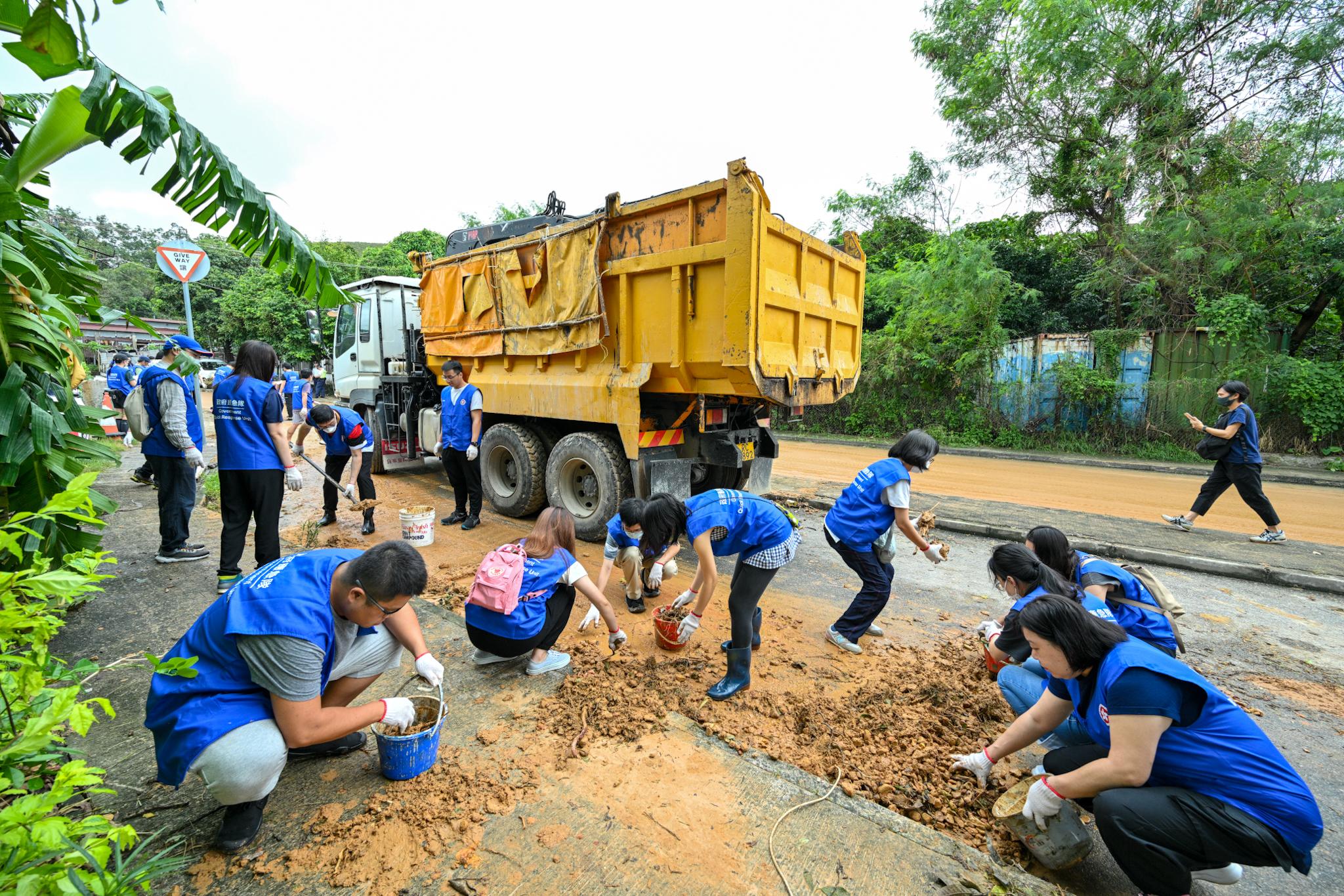 The Chief Executive, Mr John Lee, announced the activation of the mobilisation protocol for civil servants to conduct at full steam the relief work following extensive flooding caused by torrential rain brought by low pressure associated with remnants of Haikui. Photo shows supporting members carrying clean-up work by removing mud on Lo Wu Station Road today (September 9).
