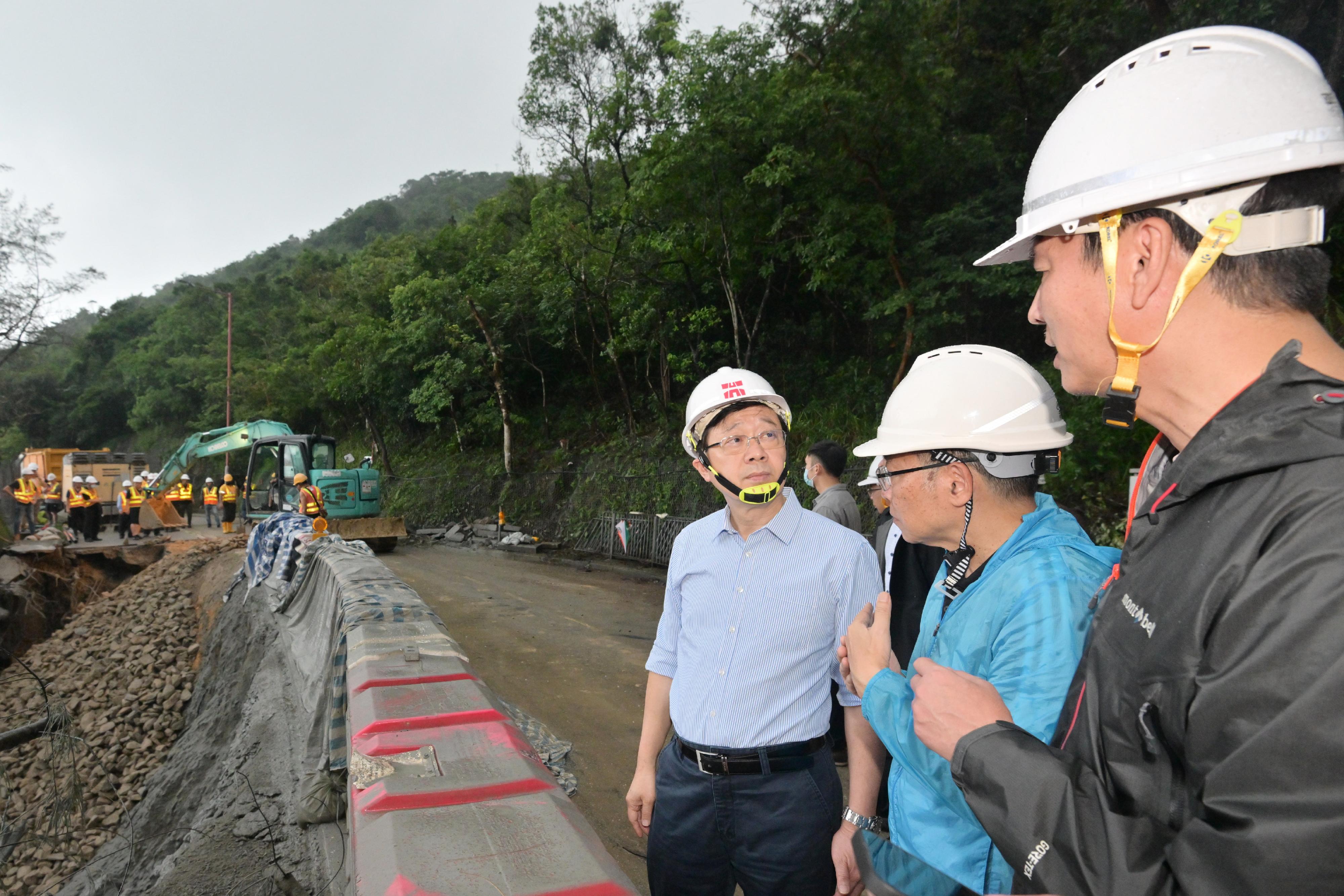 The Chief Executive, Mr John Lee, visited Shek O Road to inspect relief work in the wake of torrential rain today (September 9). Photo shows Mr Lee (third right), accompanied by the Secretary for Transport and Logistics, Mr Lam Sai-hung (second right), inspecting the road repair works.