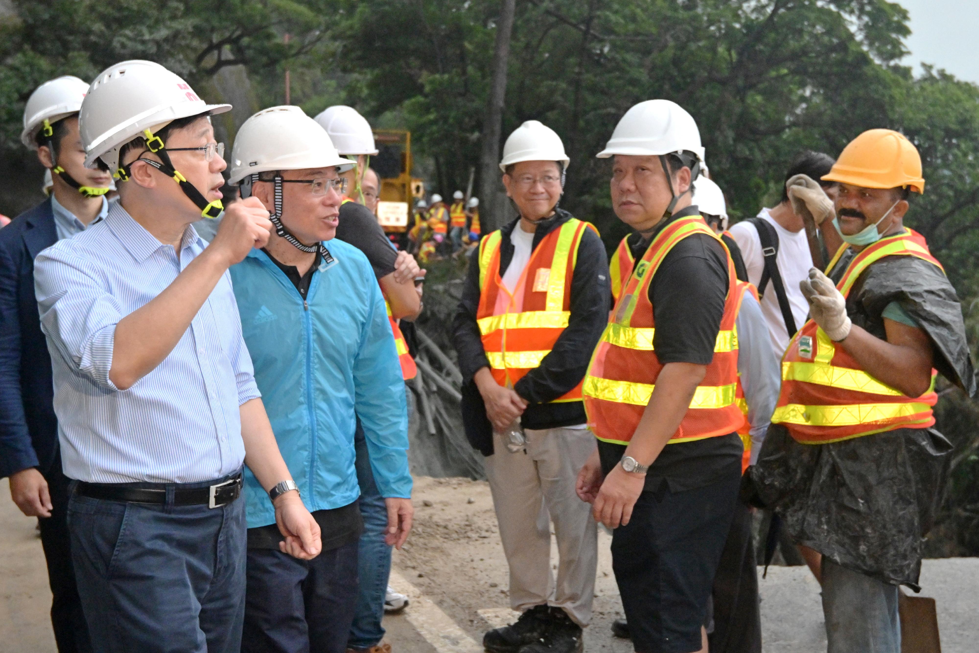 The Chief Executive, Mr John Lee, visited Shek O Road to inspect the relief work in the wake of the torrential rain today (September 9). Photo shows Mr Lee (first left) and the Secretary for Transport and Logistics, Mr Lam Sai-hung (second left), showing support to the road repair works staff.