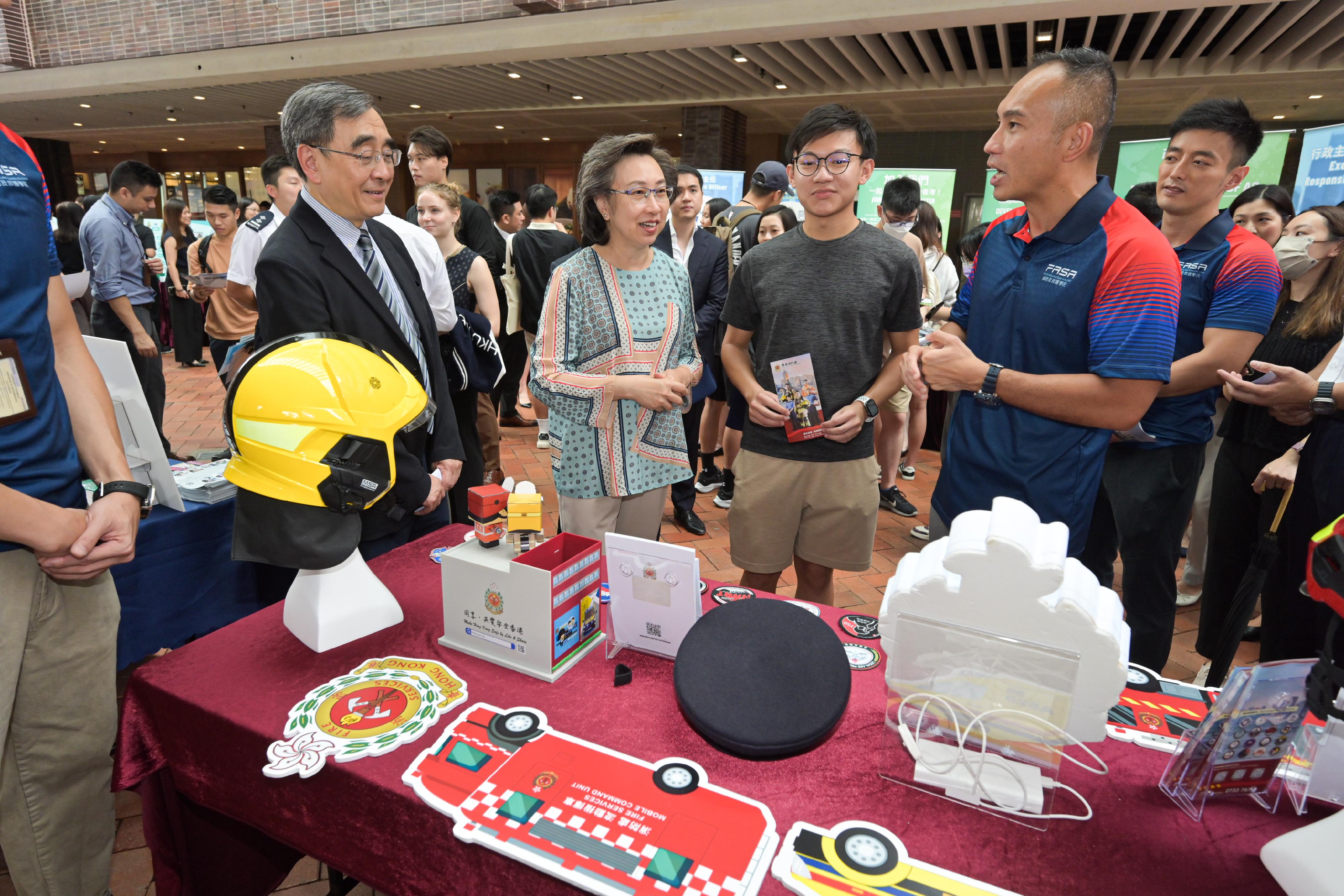 The Secretary for the Civil Service, Mrs Ingrid Yeung, visited the University of Hong Kong today (September 14), where she toured the Government Career Fair being held at the campus and encouraged students to join the civil service to serve the public. Photo shows Mrs Yeung (second left) being briefed by staff of the Fire Services Department on the department's grade.