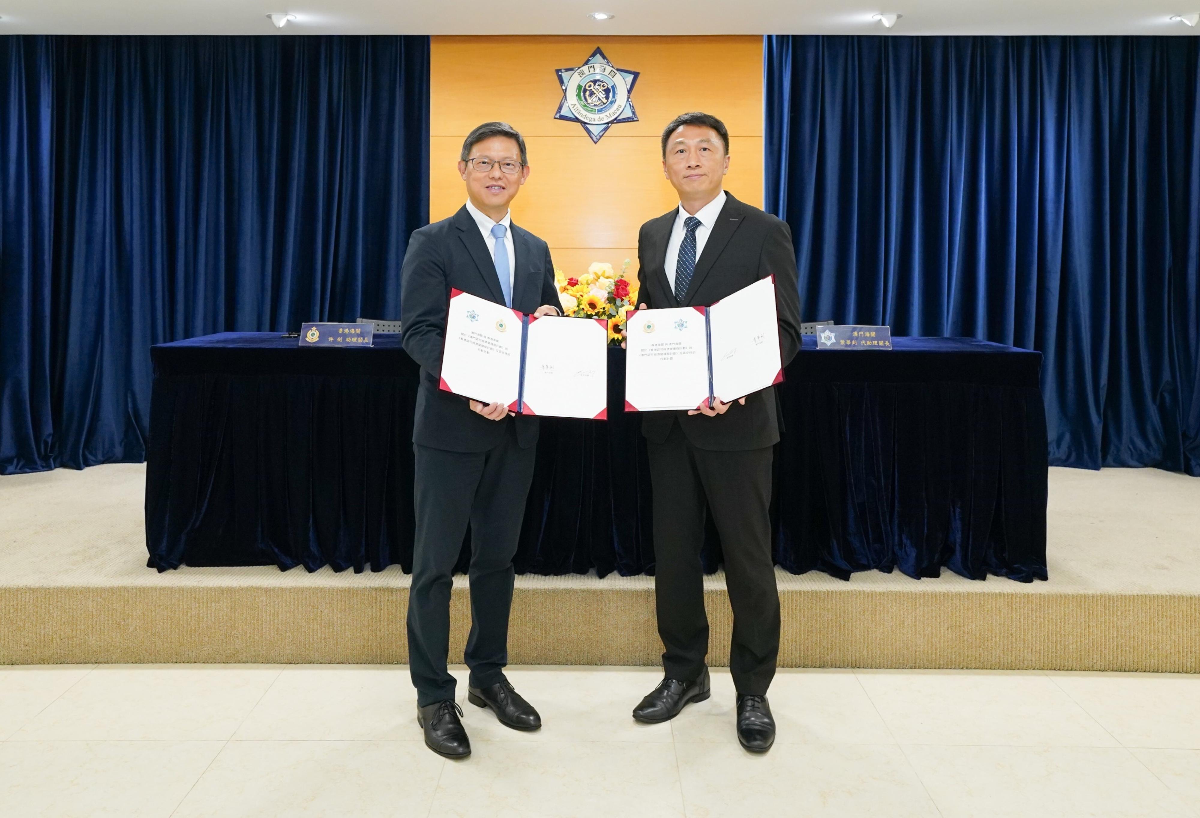 The Assistant Commissioner of Customs and Excise (Excise and Strategic Support), Mr Rudy Hui (left), today (September 14) in Macao signed the Authorized Economic Operator (AEO) Mutual Recognition Arrangement Action Plan with the Acting Assistant Director-General of Macao Customs Service, Mr Ip Va-chio (right), marking the commencement of the formal negotiation stage for mutual recognition of the AEO of both sides. Photo shows the exchange of the signed Action Plan between the two sides.

