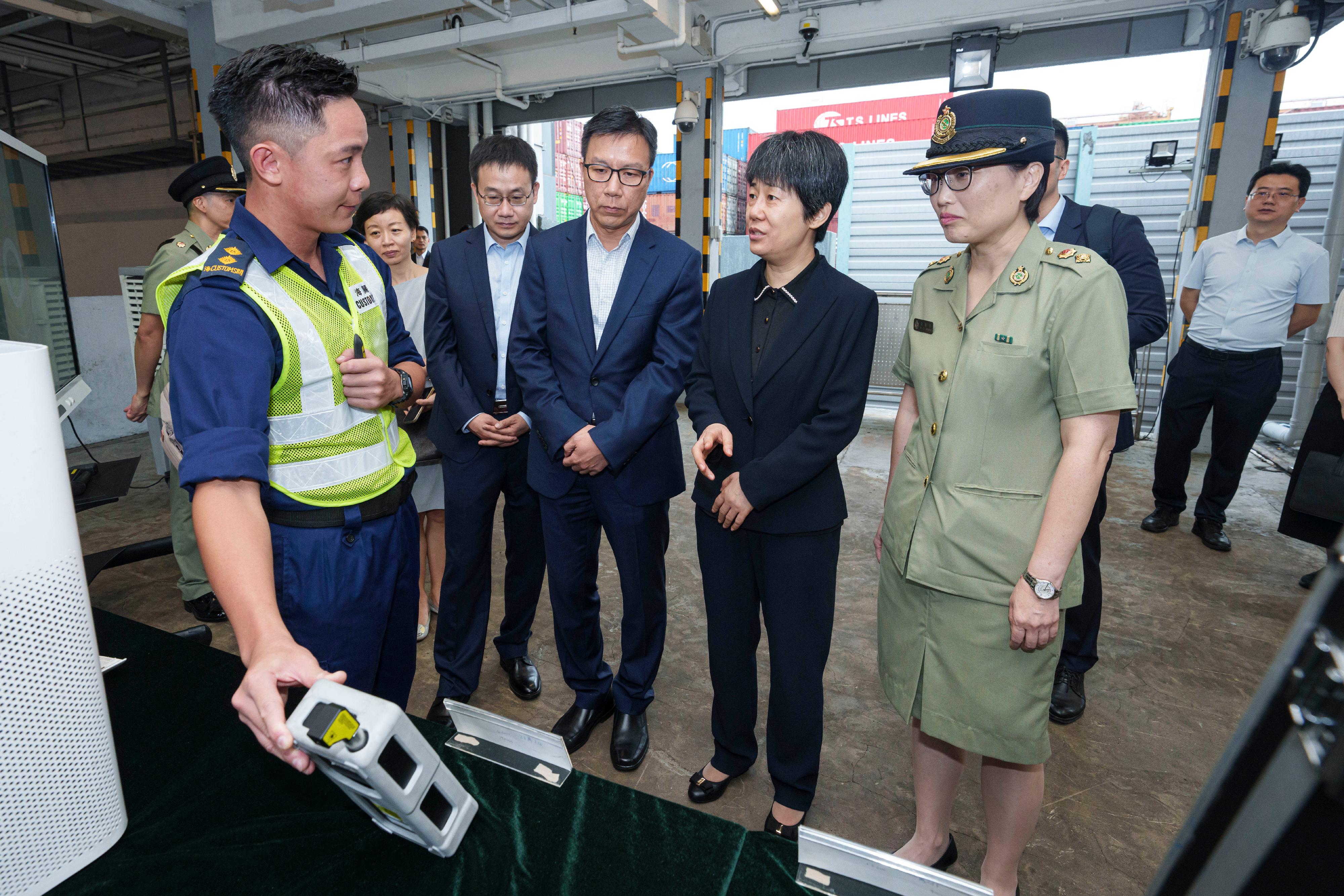The Acting Commissioner of Customs and Excise, Mr Ellis Lai (front row, centre), today (September 14) welcomed a delegation led by the Vice Minister of Commerce, Ms Guo Tingting (front row, second right), visiting Hong Kong Customs at the Kwai Chung Customhouse. Photo shows Ms Guo and members of the delegation visiting the Cargo Examination Compound to learn about the operation of sea cargo clearance of Hong Kong Customs.