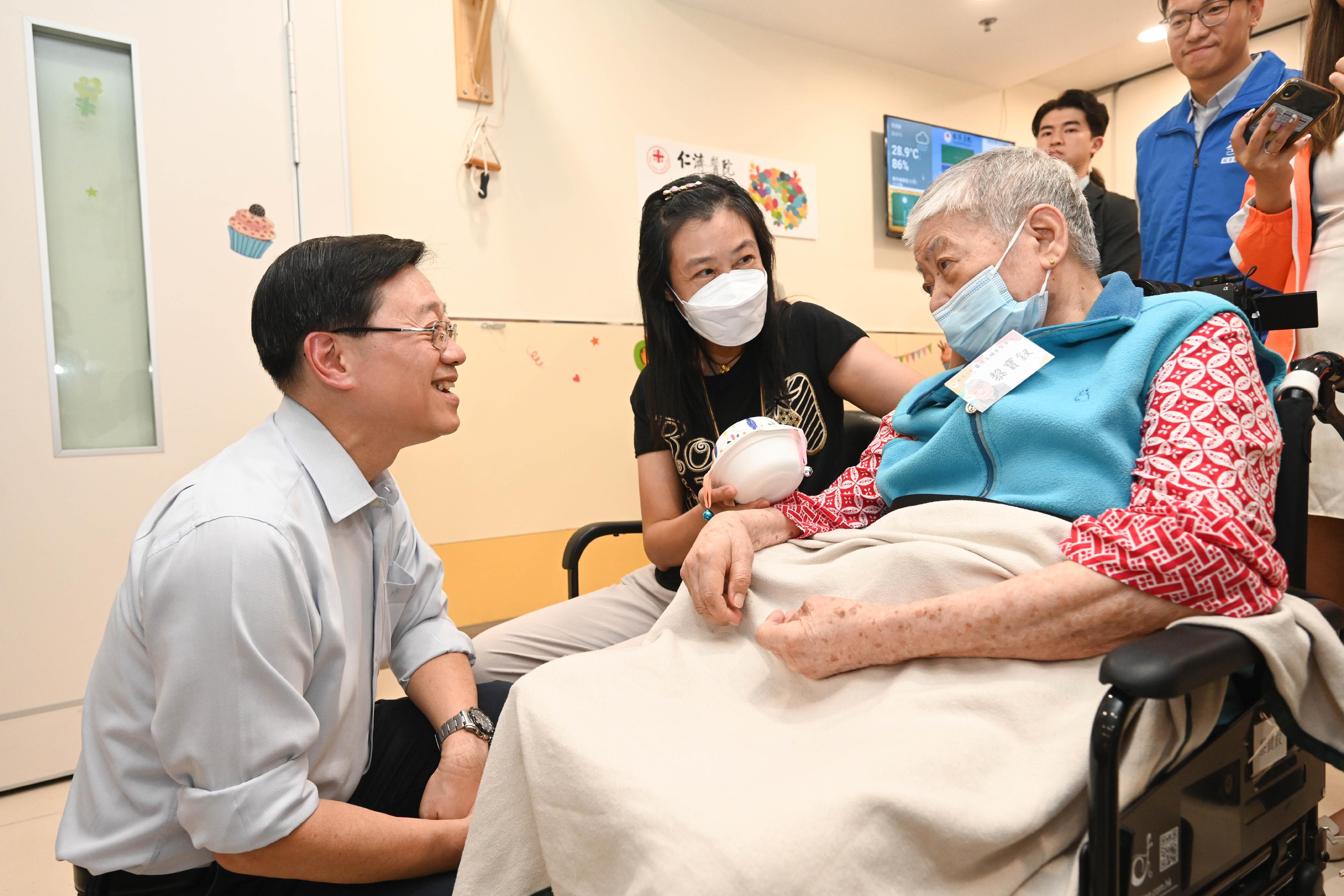 The Chief Executive, Mr John Lee, visited Tsuen Wan to gather public views on the upcoming Policy Address today (September 15). Photo shows Mr Lee (first left) chatting with an elderly person and the family carer at the Yan Chai Hospital Yim Tsui Yuk Shan Active Mind Centre.