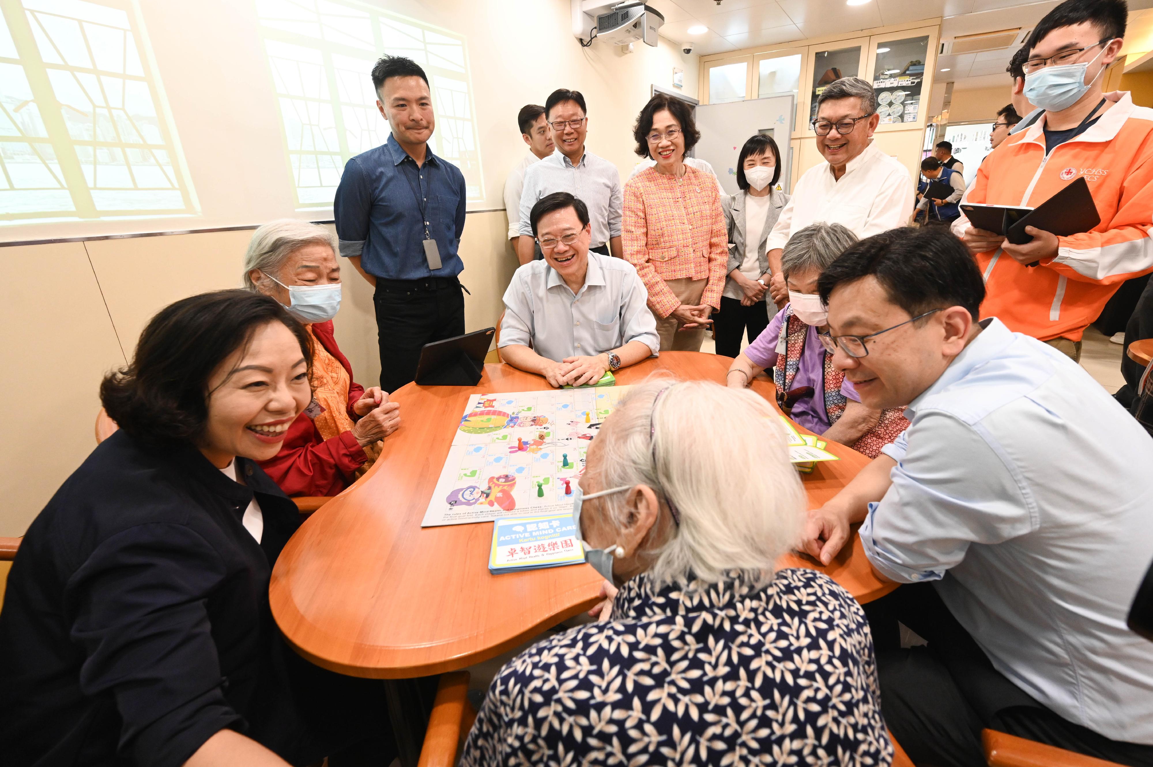 The Chief Executive, Mr John Lee, visited Tsuen Wan to gather public views on the upcoming Policy Address today (September 15). Photo shows Mr Lee (fourth left); the Secretary for Home and Youth Affairs, Miss Alice Mak (first left); and the Secretary for Labour and Welfare, Mr Chris Sun (first right), playing a board game with elderly people at the Yan Chai Hospital Yim Tsui Yuk Shan Active Mind Centre.