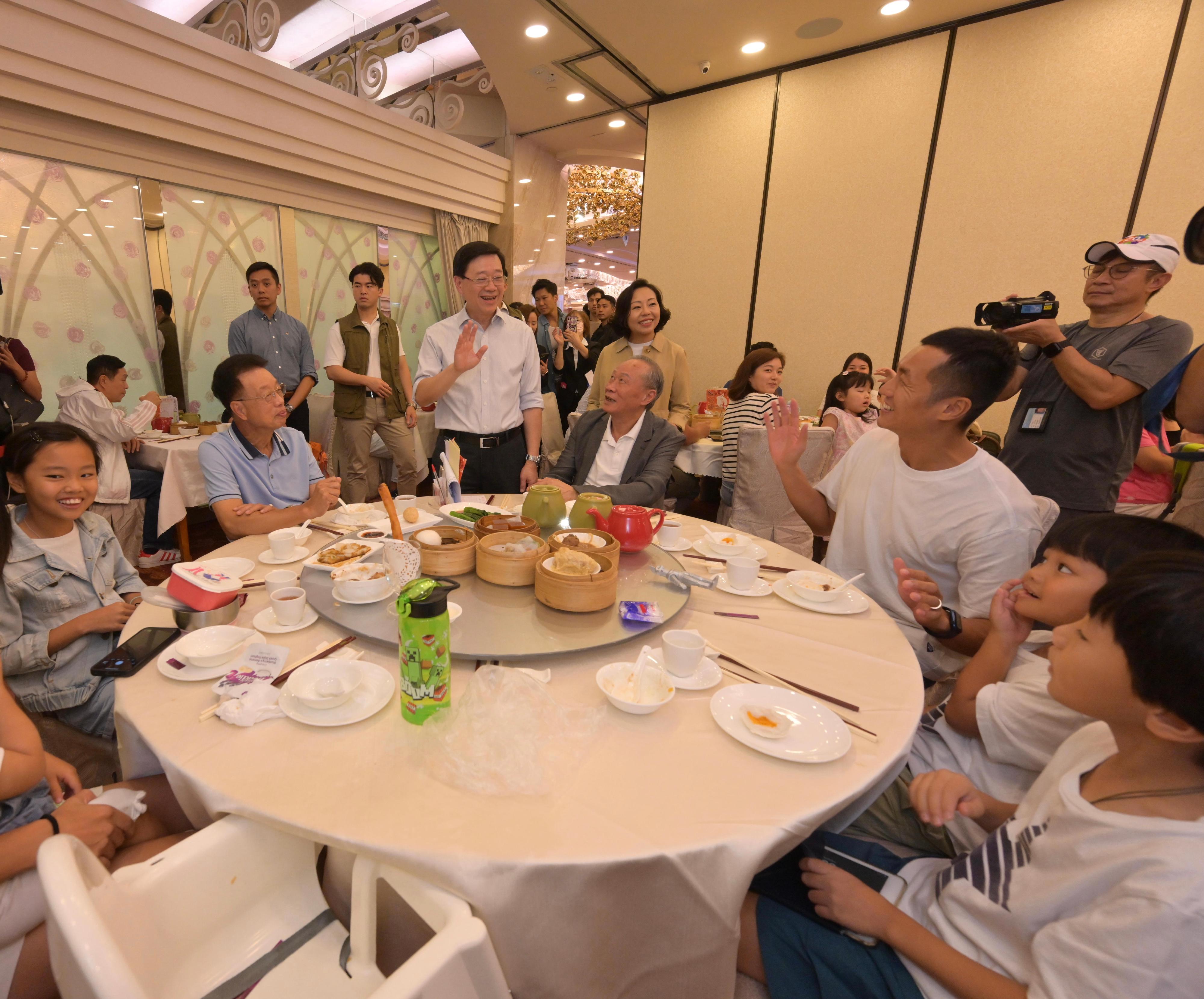 The Chief Executive, Mr John Lee, visited Yuen Long to gather public views on the upcoming Policy Address today (September 17). Photo shows Mr Lee (back row, third left), and the Secretary for Home and Youth Affairs, Miss Alice Mak (back row, fourth left), interacting with members of the public and listening to their views on the upcoming Policy Address.