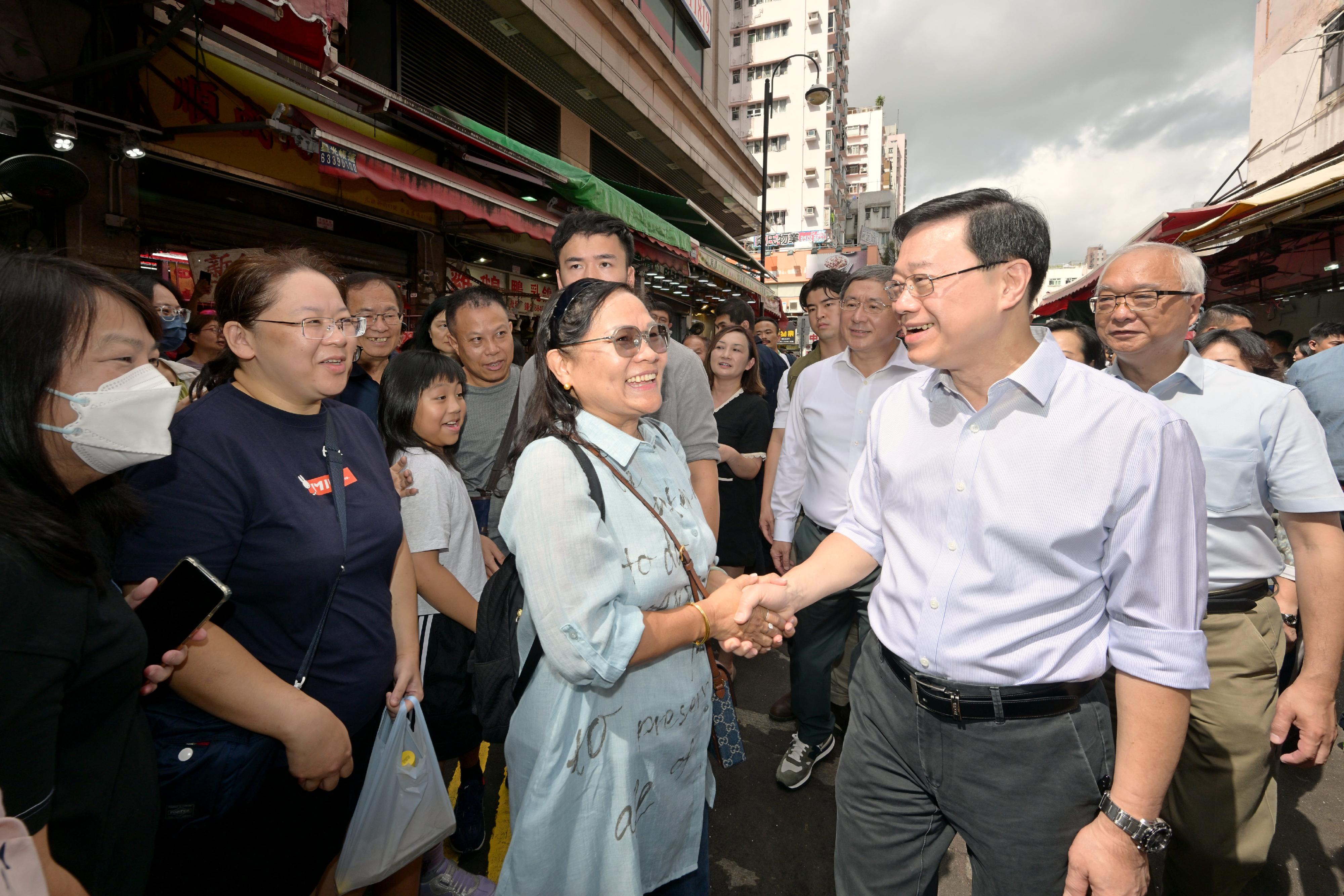 The Chief Executive, Mr John Lee, visited Yuen Long to gather public views on the upcoming Policy Address today (September 17). Photo shows Mr Lee (second right), accompanied by the Deputy Chief Secretary for Administration, Mr Cheuk Wing-hing (third right), and the Secretary for Environment and Ecology, Mr Tse Chin-wan (first right), interacting with members of the public in the district.