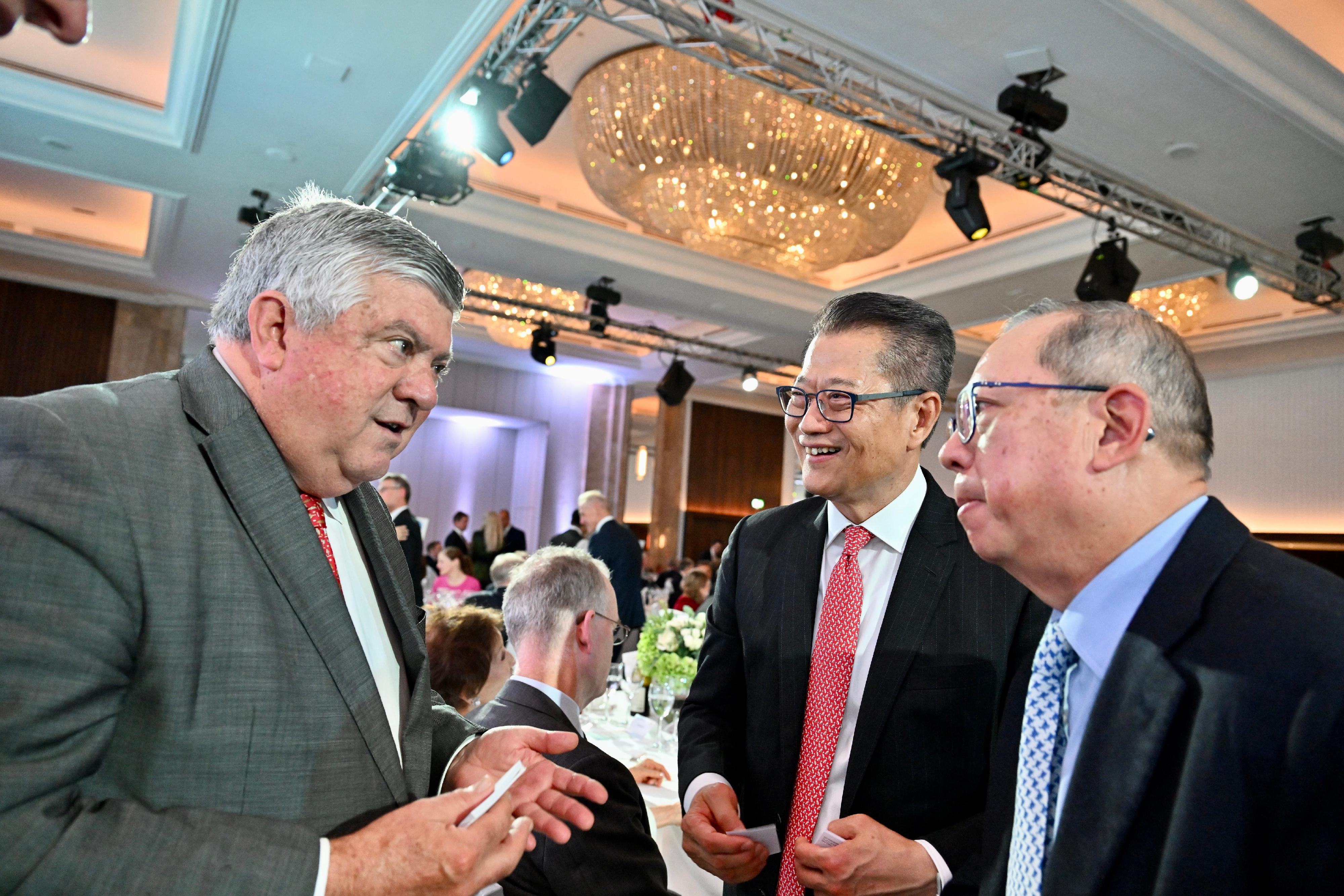 The Financial Secretary, Mr Paul Chan, arrived in London yesterday (September 20, London time) to begin his visit to London, and attended the Hong Kong Dinner organised by the Hong Kong Trade Development Council. Photo shows Mr Chan (second right) and Chairman of the Hong Kong Trade Development Council, Dr Peter Lam (first right) exchanging with guests attending the dinner.