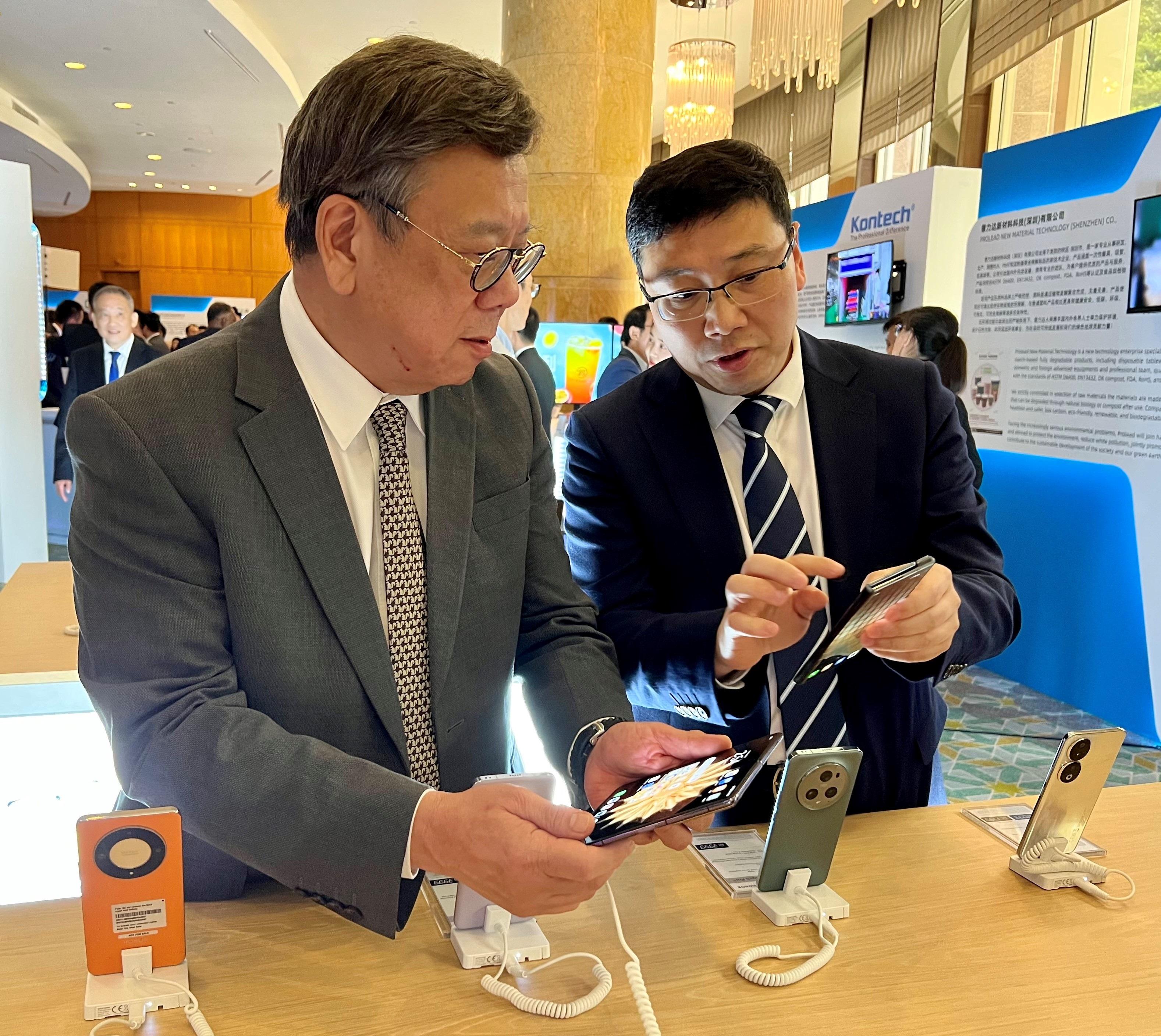 The Secretary for Commerce and Economic Development, Mr Algernon Yau, attended the China (Shenzhen, Hong Kong) - ASEAN (Kuala Lumpur) Emerging Industries Partnering Conference in Kuala Lumpur, Malaysia, today (September 21). Photo shows Mr Yau (left) being briefed on products exhibited at the conference.