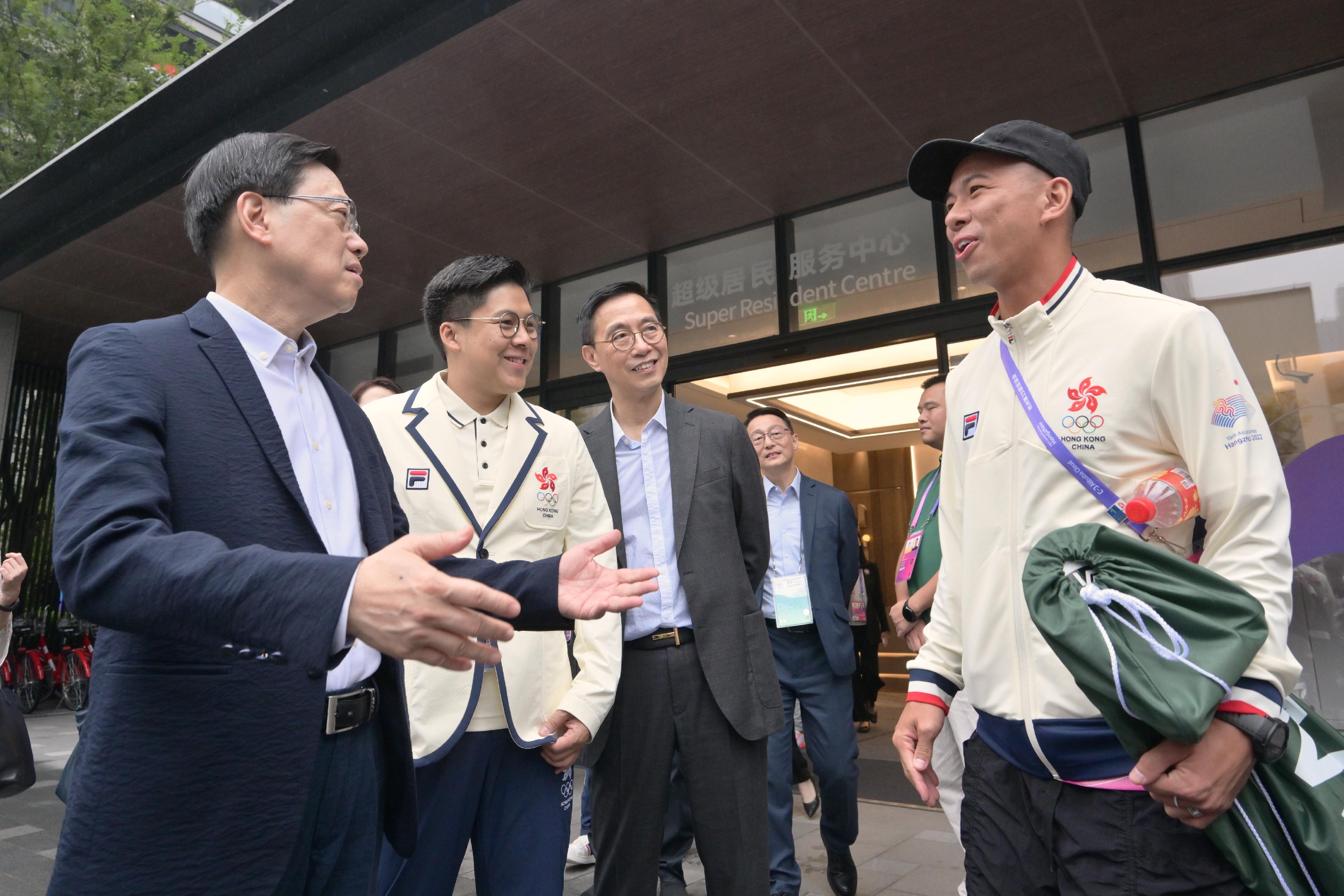 The Chief Executive, Mr John Lee, led a delegation of the Hong Kong Special Administrative Region Government to attend the opening ceremony of the 19th Asian Games Hangzhou (Asian Games) today (September 22). Photo shows (from left) Mr Lee; the Chef de Mission of the Hong Kong, China Delegation to the Asian Games, Mr Kenneth Fok; and the Secretary for Culture, Sports and Tourism, Mr Kevin Yeung, interacting with a Hong Kong athlete.