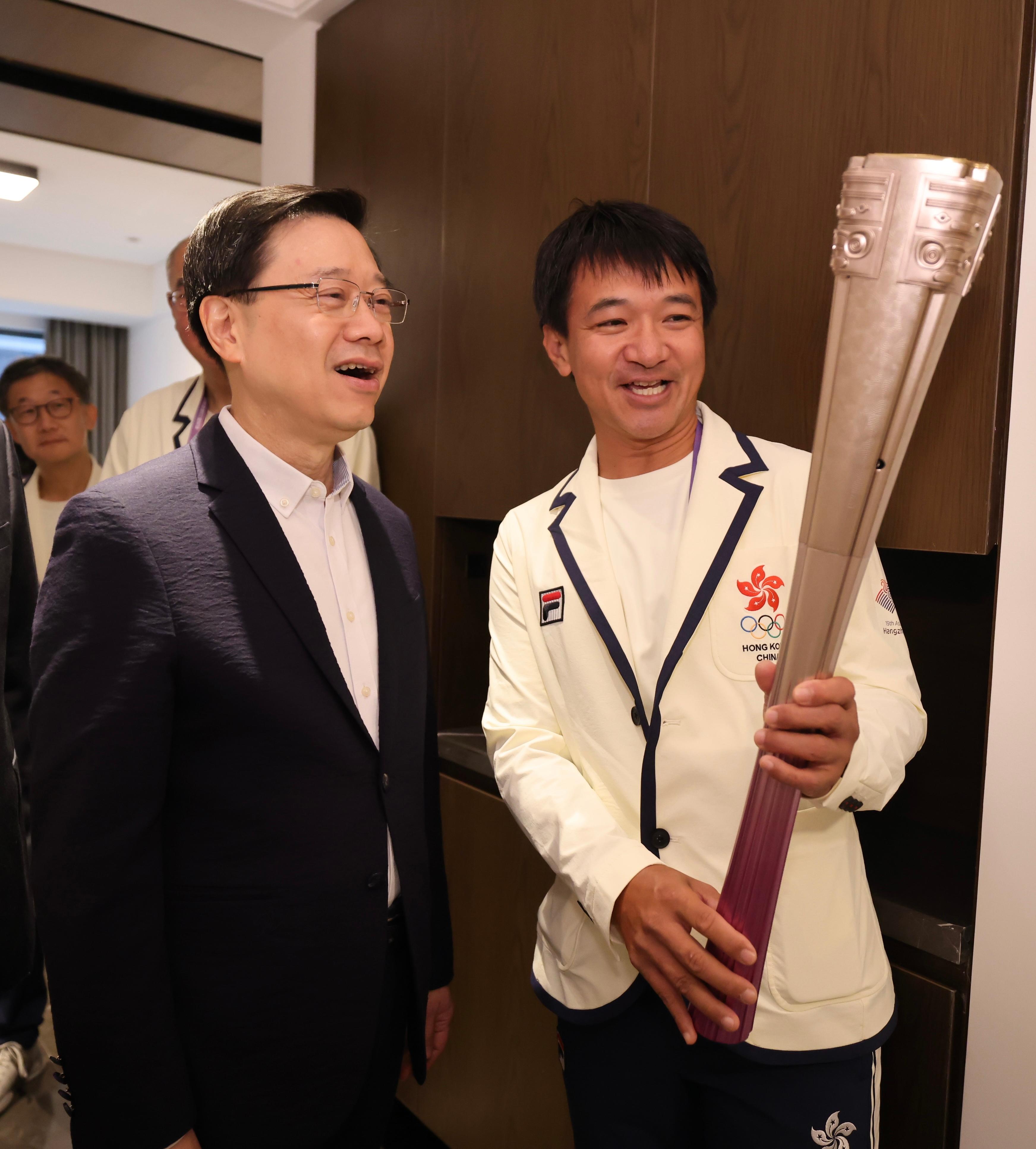 The Chief Executive, Mr John Lee, led a delegation of the Hong Kong Special Administrative Region Government to attend the opening ceremony of the 19th Asian Games Hangzhou (Asian Games) today (September 22). Photo shows Mr Lee (left) listening to the sharing from cyclist Wong Kam-po (right) on his experience and feelings as a torch bearer of the Asian Games.
