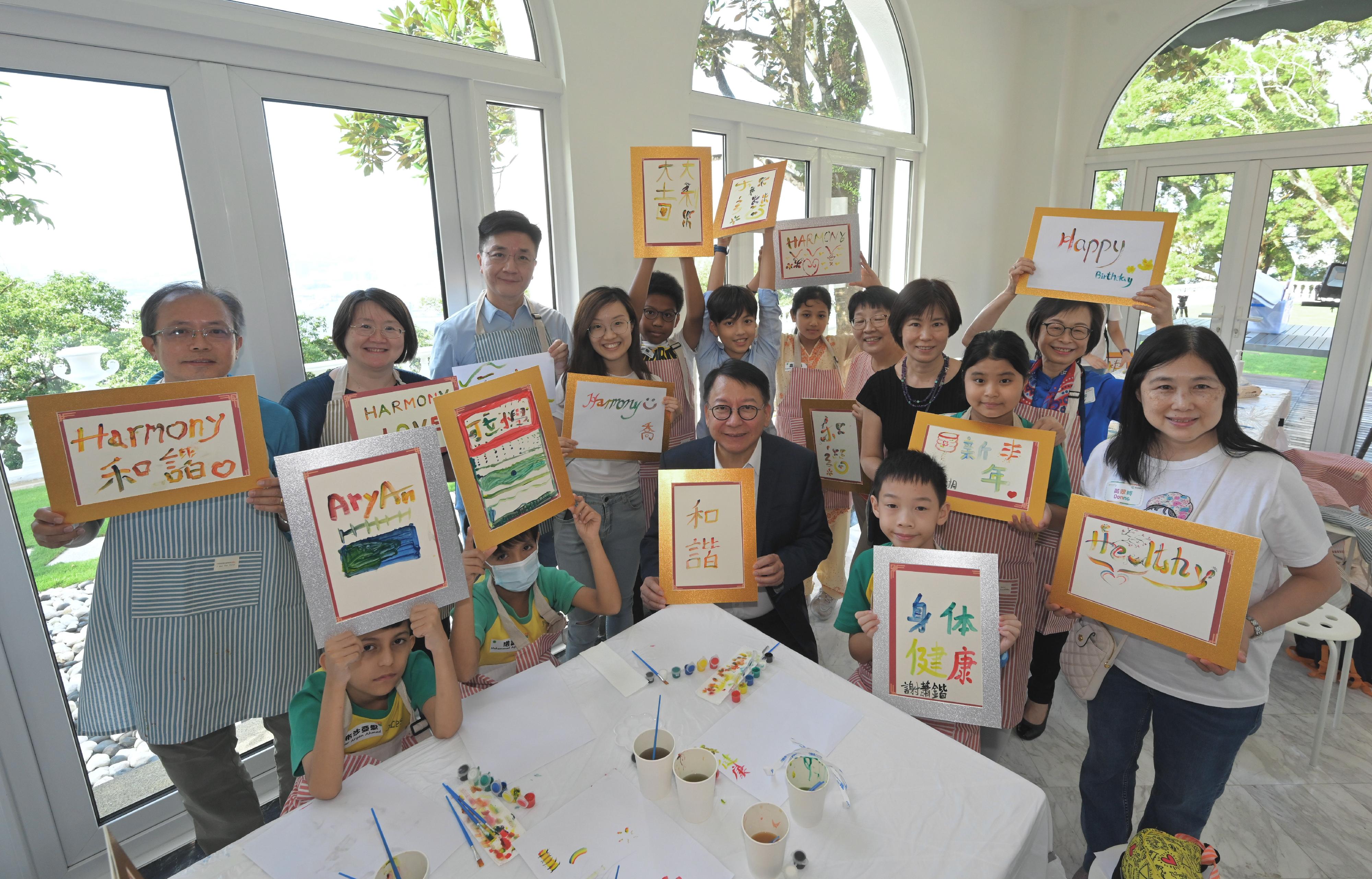 The Chief Secretary for Administration and Chairperson of the Commission on Children (CoC), Mr Chan Kwok-ki, hosted about 40 primary school students at Victoria House today (September 23) at the "Walk with Kids" stakeholder engagement event of the CoC on the theme of harmony and cultural inclusion. They interacted with one another and celebrated the Mid-Autumn Festival together. Photo shows Mr Chan (front row, centre) and students showing their rainbow calligraphy works.
