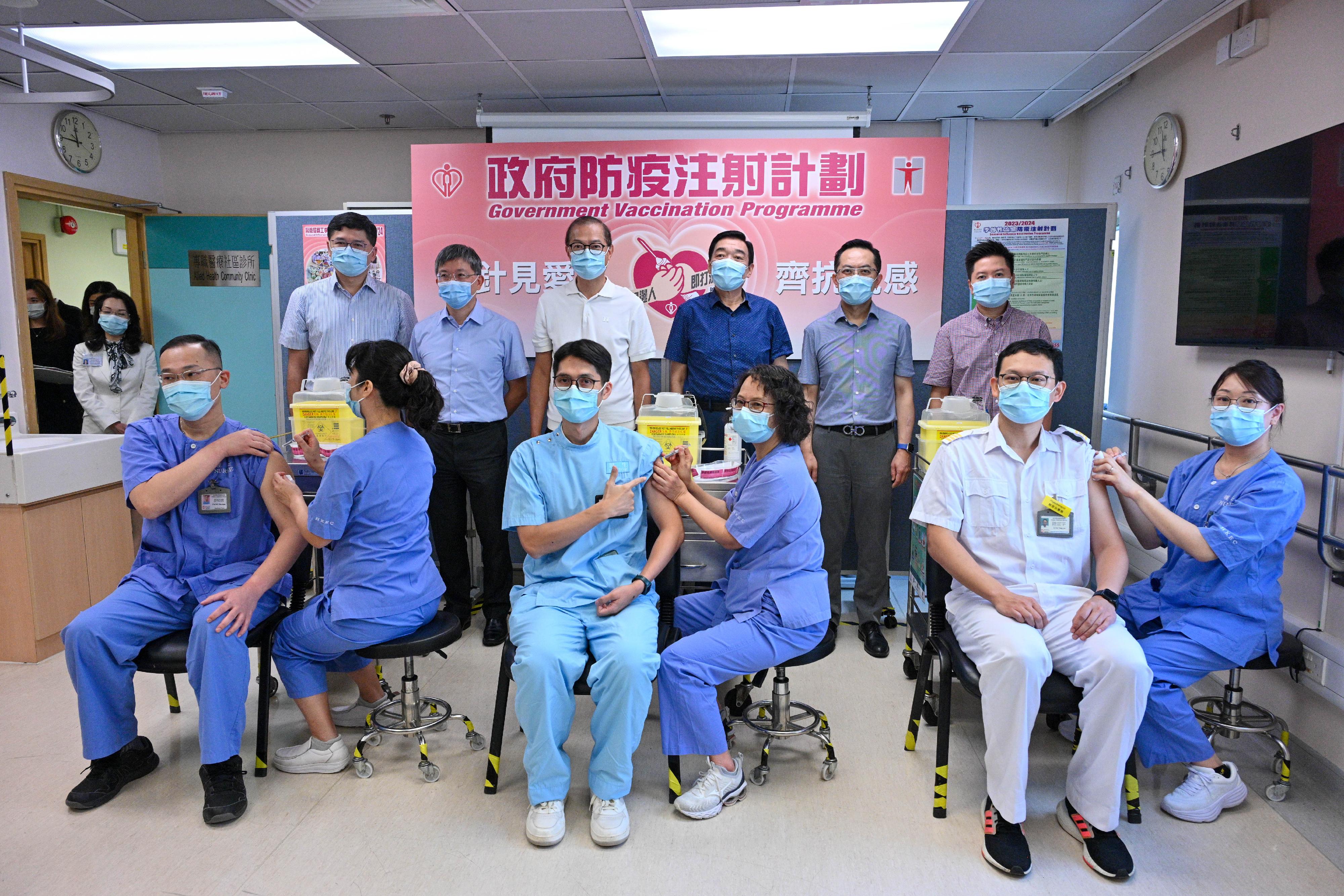 The Secretary for Health, Professor Lo Chung-mau (back row, third left); the Permanent Secretary for Health, Mr Thomas Chan (back row, second left); the Director of Health, Dr Ronald Lam (back row, second right); the Controller of the Centre for Health Protection of the Department of Health, Dr Edwin Tsui (back row, first right); the Chairman of the Hospital Authority (HA), Mr Henry Fan (back row, third right); and the Chief Executive of the HA, Dr Tony Ko (back row, first left), look on as frontline healthcare workers receive the seasonal influenza vaccination at the Sai Wan Ho General Out-patient Clinic today (September 28).