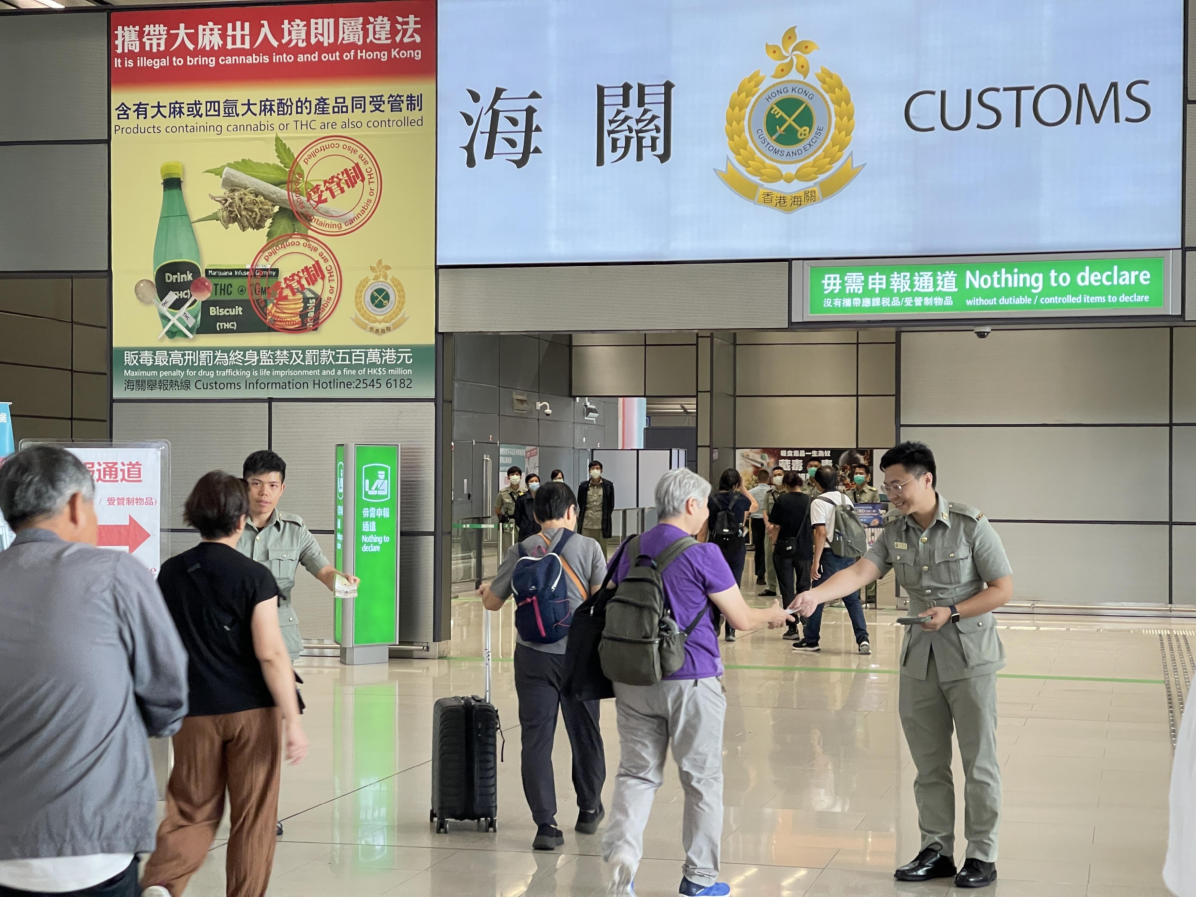 ​Hong Kong Customs has drawn up a series of measures to prepare for the arrival of Mainland visitors and cater for the commuting needs of Hong Kong citizens during the National Day Golden Week period to ensure smooth passenger, vehicular and goods flows at each control point. Photo shows Customs officers distributing pamphlets of Smart Guide to Passenger Clearance to remind visitors not to carry prohibited and controlled articles in and out of Hong Kong at boundary control points.