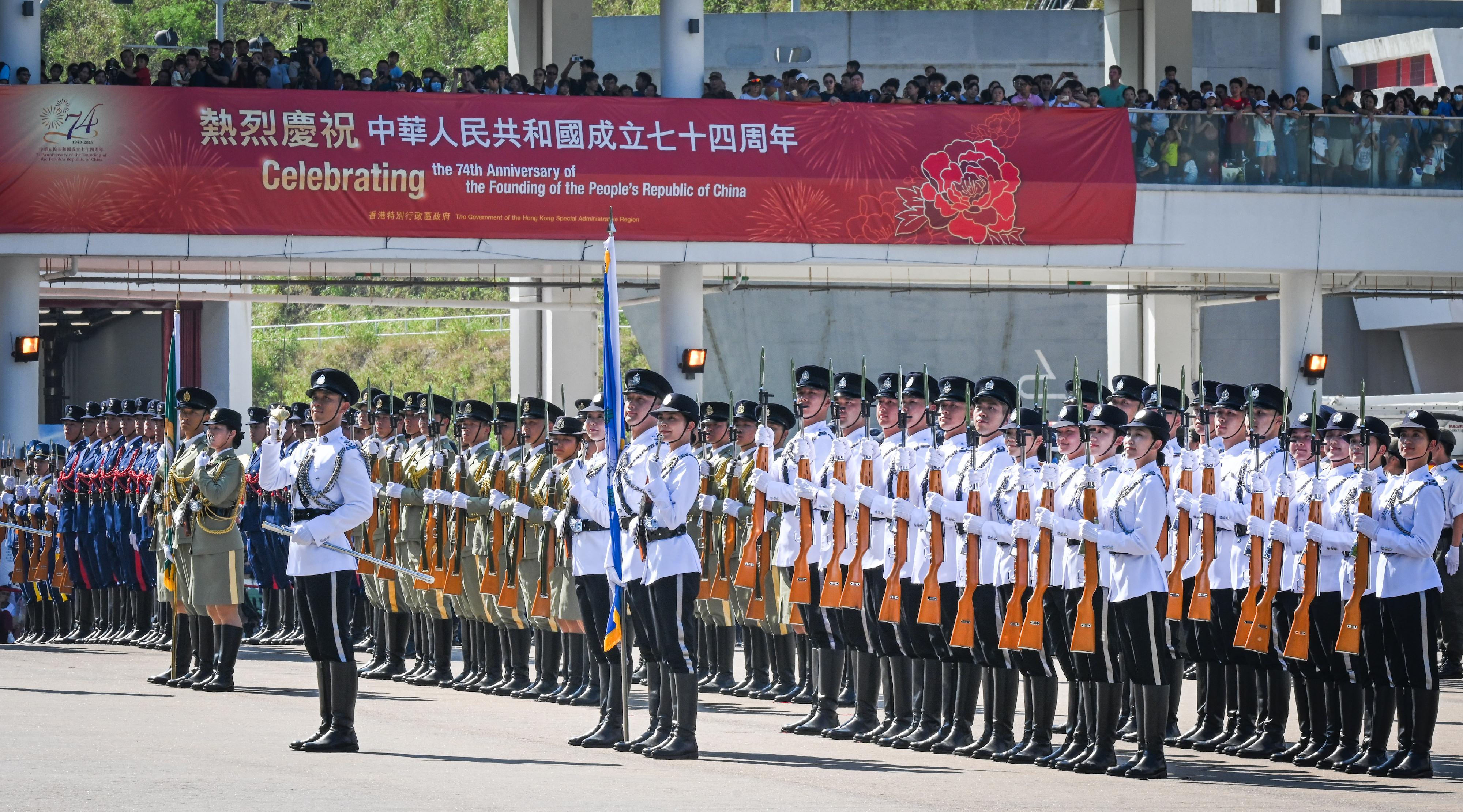 The Security Bureau led its disciplined services and auxiliary services, together with youth uniformed groups, to hold the Parade by Disciplined Services and Youth Groups cum Carnival for Celebrating the 74th Anniversary of the Founding of the People's Republic of China at the Fire and Ambulance Services Academy in Tseung Kwan O today (October 1) to celebrate the National Day with members of the public. Photo shows the disciplined services ceremonial guard and the youth uniformed groups marching into the venue with the Chinese-style foot drill.