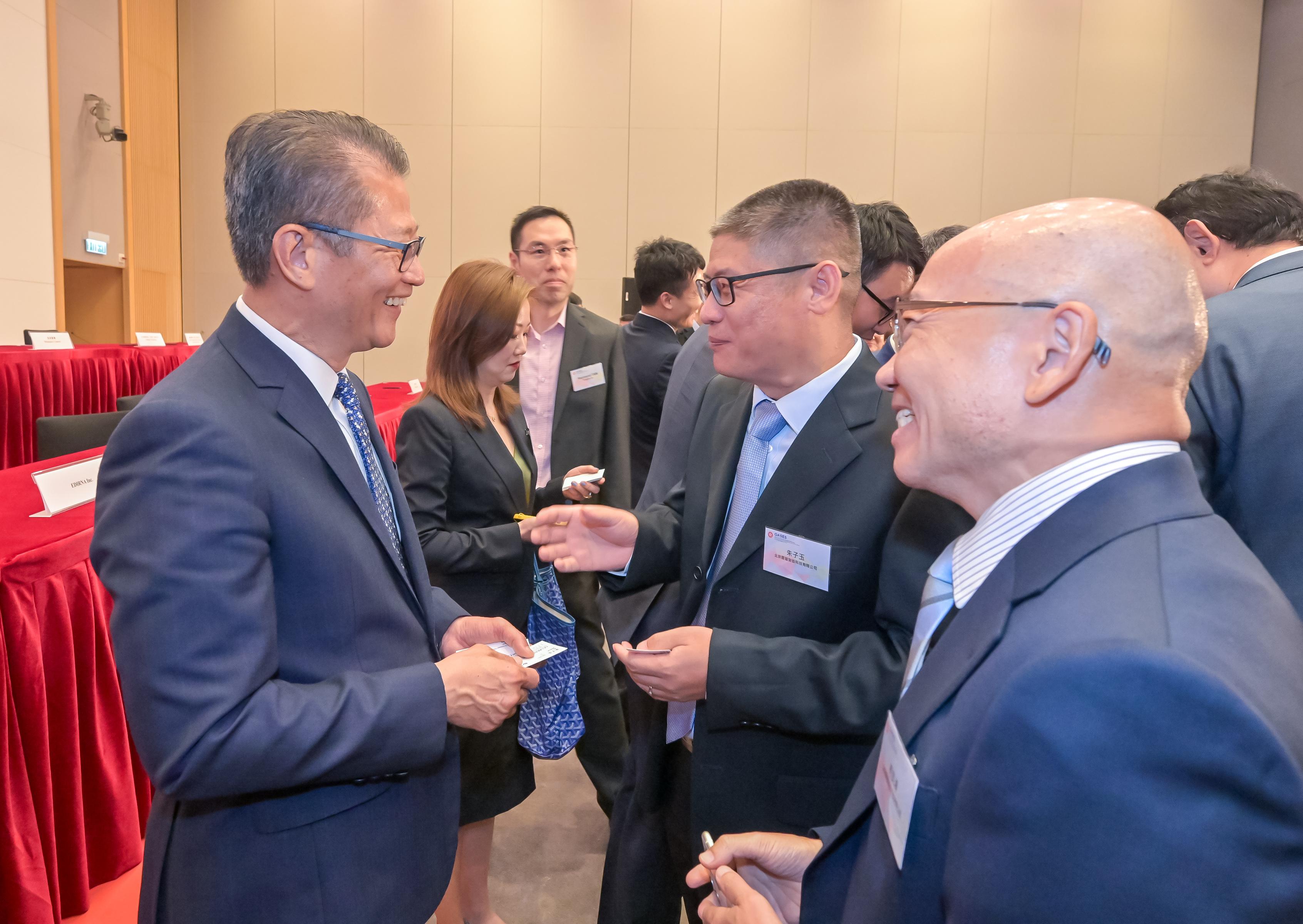 The Office for Attracting Attracting Strategic Enterprises (OASES) held the Launching Ceremony of OASES Partnership. Photo shows the Financial Secretary, Mr Paul Chan (first left), interacting with the representatives of strategic enterprises.