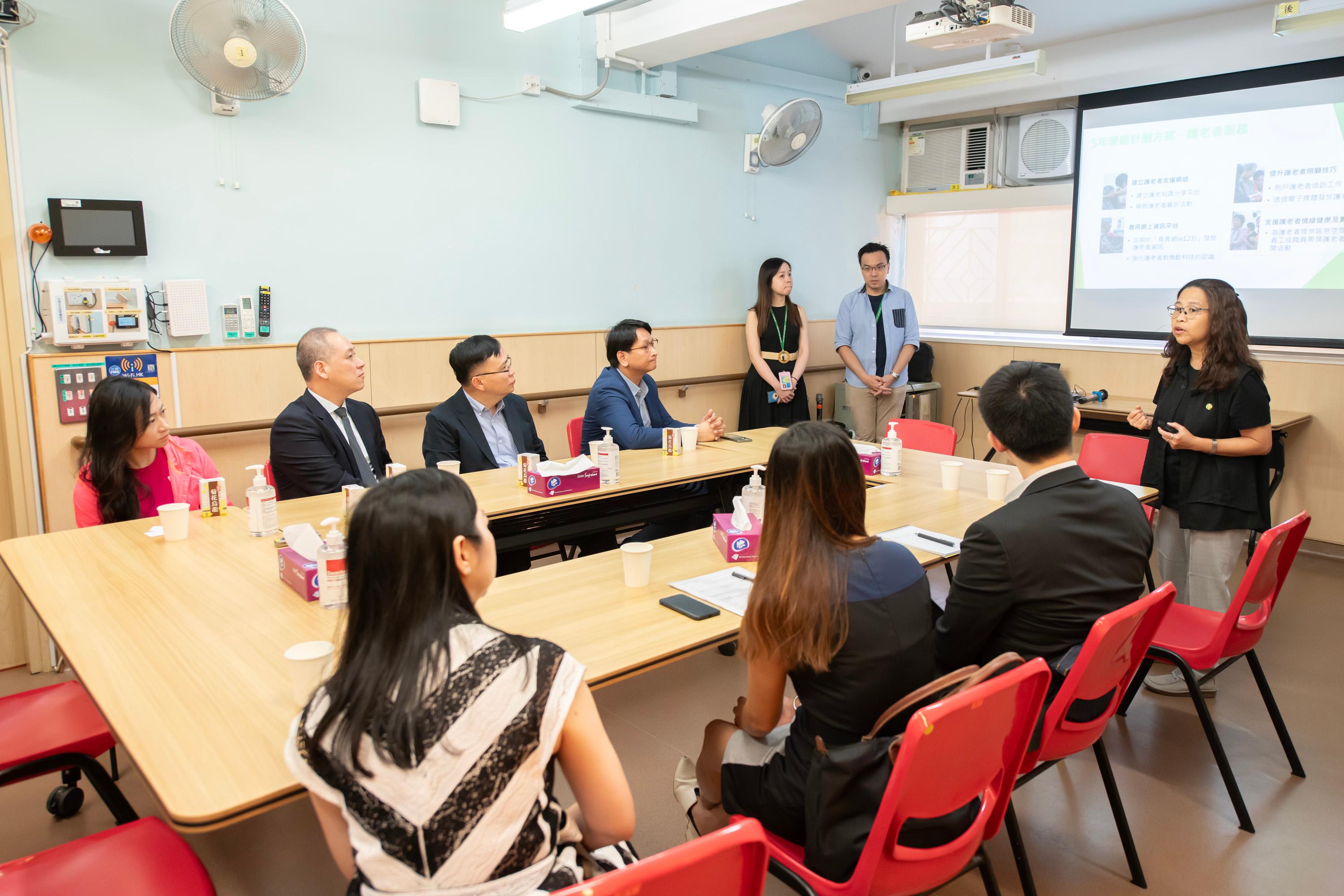 Legislative Council (LegCo) Members visit an elderly person living alone in Tai Wo Hau Estate and conduct a site visit to a district elderly community centre today (October 5) to learn about the support services for elderly singletons. Photo shows LegCo Members receiving a briefing on elderly services at the SAGE Chan Tseng Hsi Kwai Chung District Elderly Community Centre.