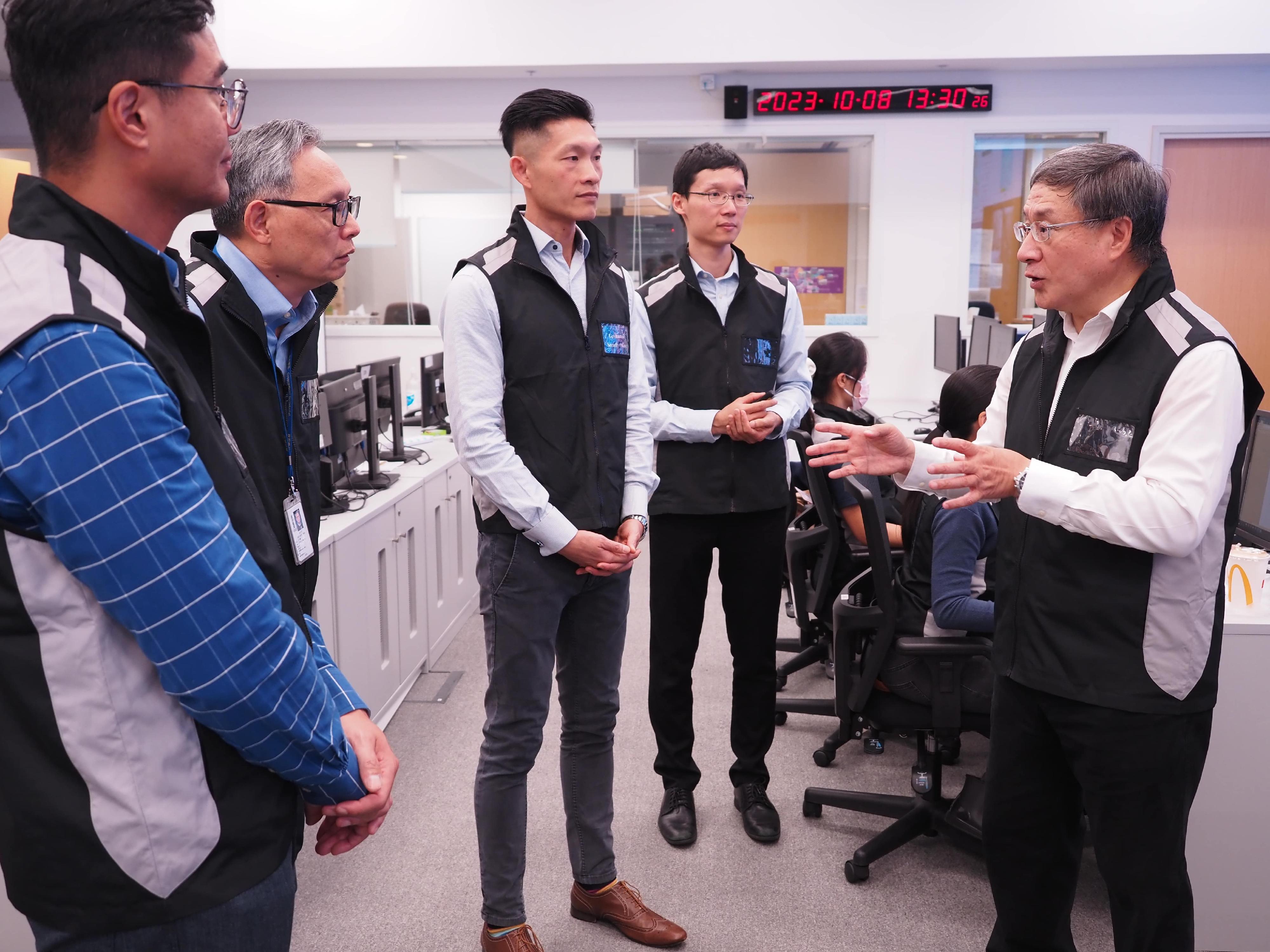 The Acting Chief Secretary for Administration, Mr Cheuk Wing-hing (first right), and the Acting Secretary for Security, Mr Michael Cheuk (second left), visit the Emergency Monitoring and Support Centre today (October 8).