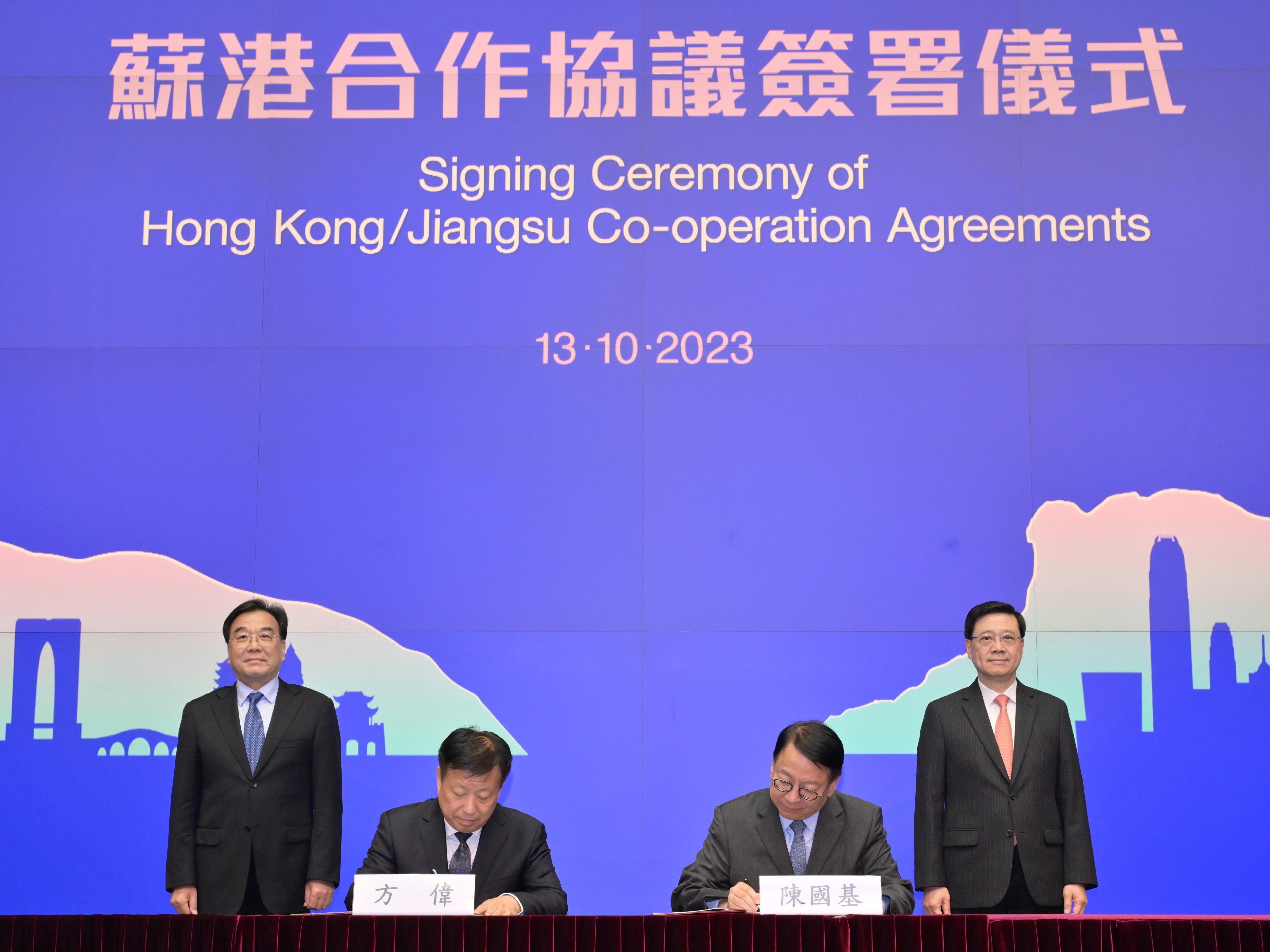 The Chief Executive, Mr John Lee, and the Secretary of the CPC Jiangsu Provincial Committee, Mr Xin Changxing, leading the delegations of the governments of the Hong Kong Special Administrative Region and Jiangsu respectively, held the High-Level Meeting cum Signing Ceremony of Hong Kong/Jiangsu Co-operation Agreements in Hong Kong today (October 13). Photo shows Mr Lee (back row, right) and Mr Xin (back row, left) witnessing the signing of the "Co-operation Agreement between the People’s Government of Jiangsu Province and the Government of the Hong Kong Special Administration Region on Deepening the Exchange of Jiangsu and Hong Kong" by the Chief Secretary for Administration, Mr Chan Kwok-ki (front row, right), and the Vice Governor of Jiangsu Provincial People's Government Mr Fang Wei (front row, left).