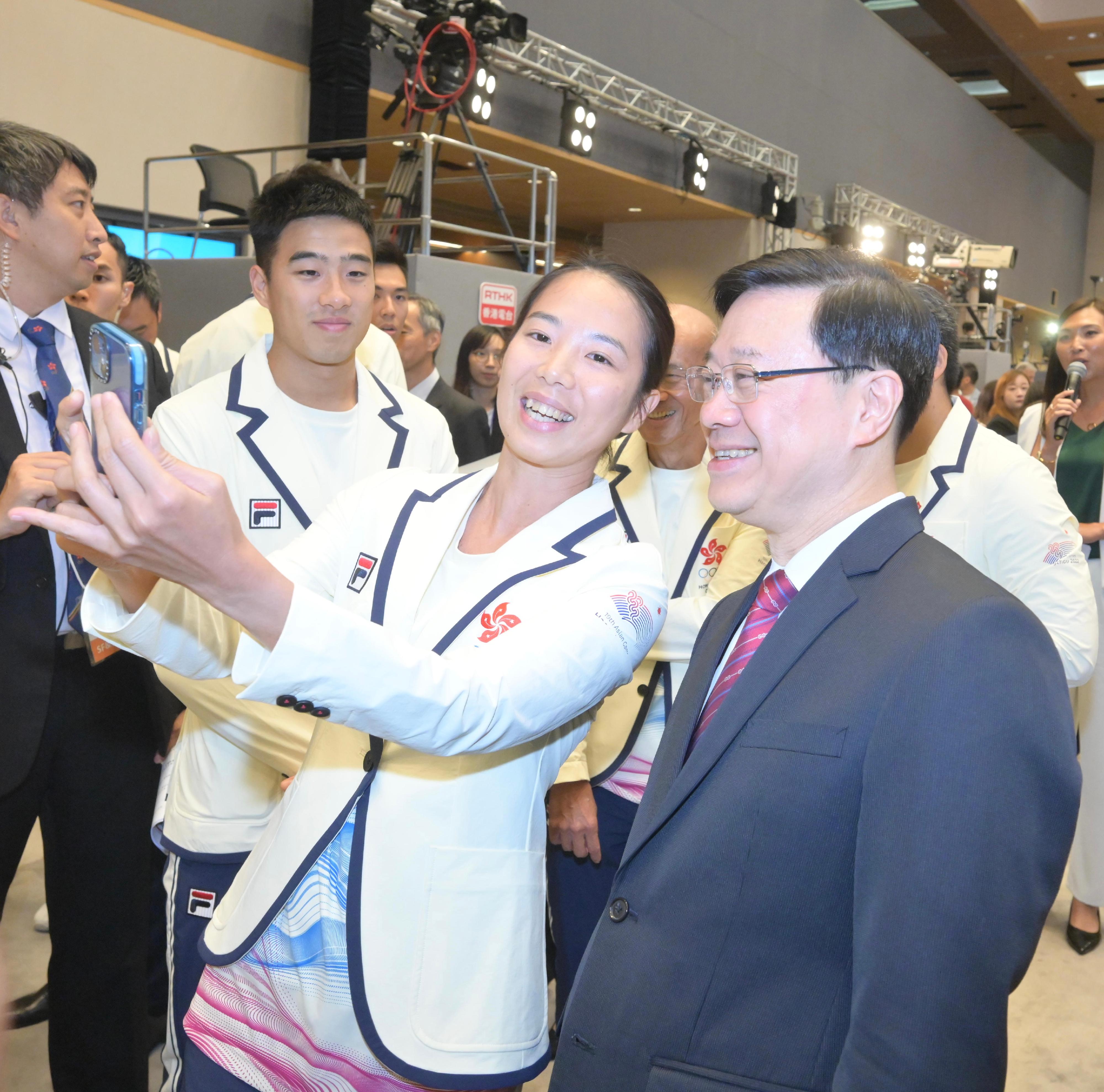 行政长官李家超今日（十月十四日）出席杭州第19届亚洲运动会中国香港代表团返港欢迎仪式。图示李家超（右）与运动员交流。