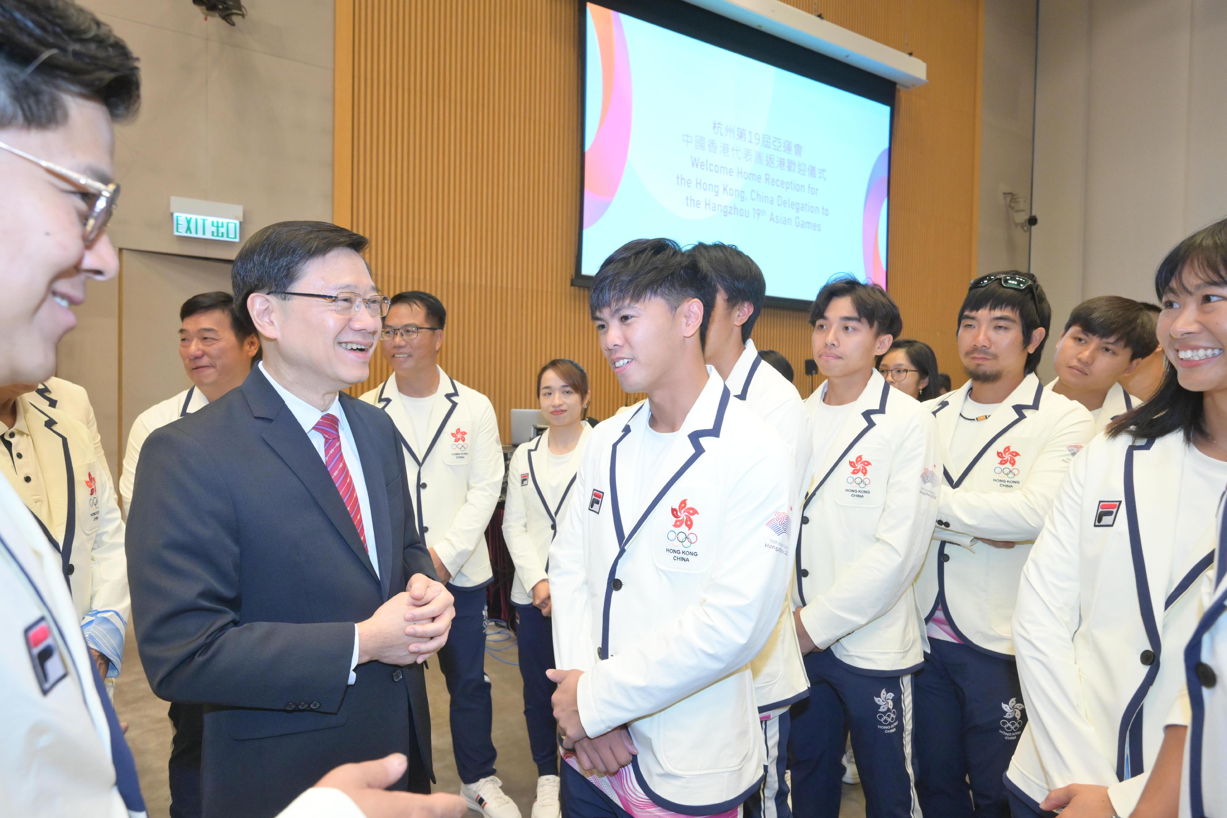 行政长官李家超今日（十月十四日）出席杭州第19届亚洲运动会中国香港代表团返港欢迎仪式。图示李家超（左二）与运动员交流。