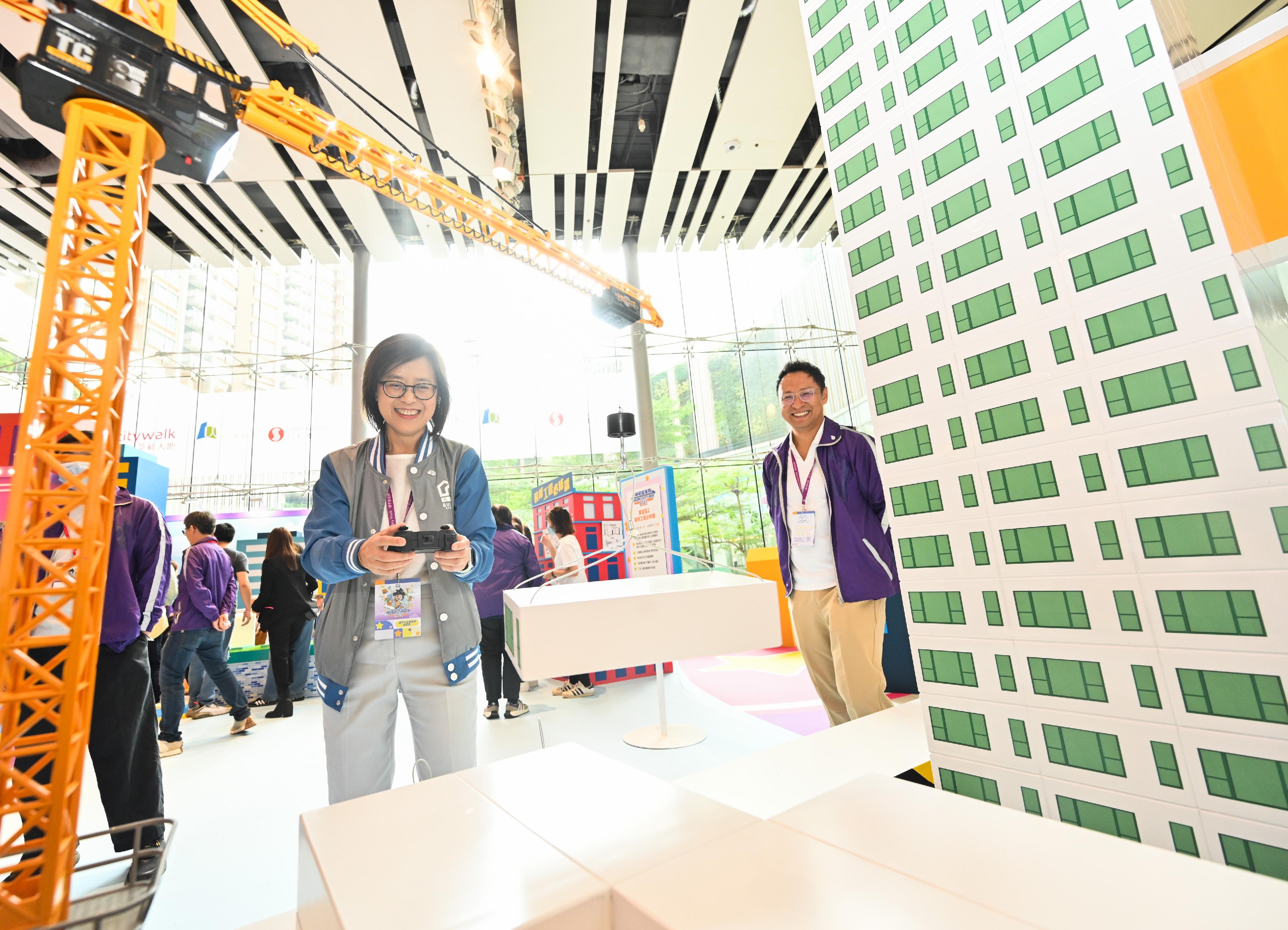 The Buildings Department launched Building Safety Week 2023 today (October 21). Photo shows the Director of Buildings, Ms Clarice Yu, trying one of the booth games at the Building Safety Carnival after the opening ceremony of Building Safety Week 2023.