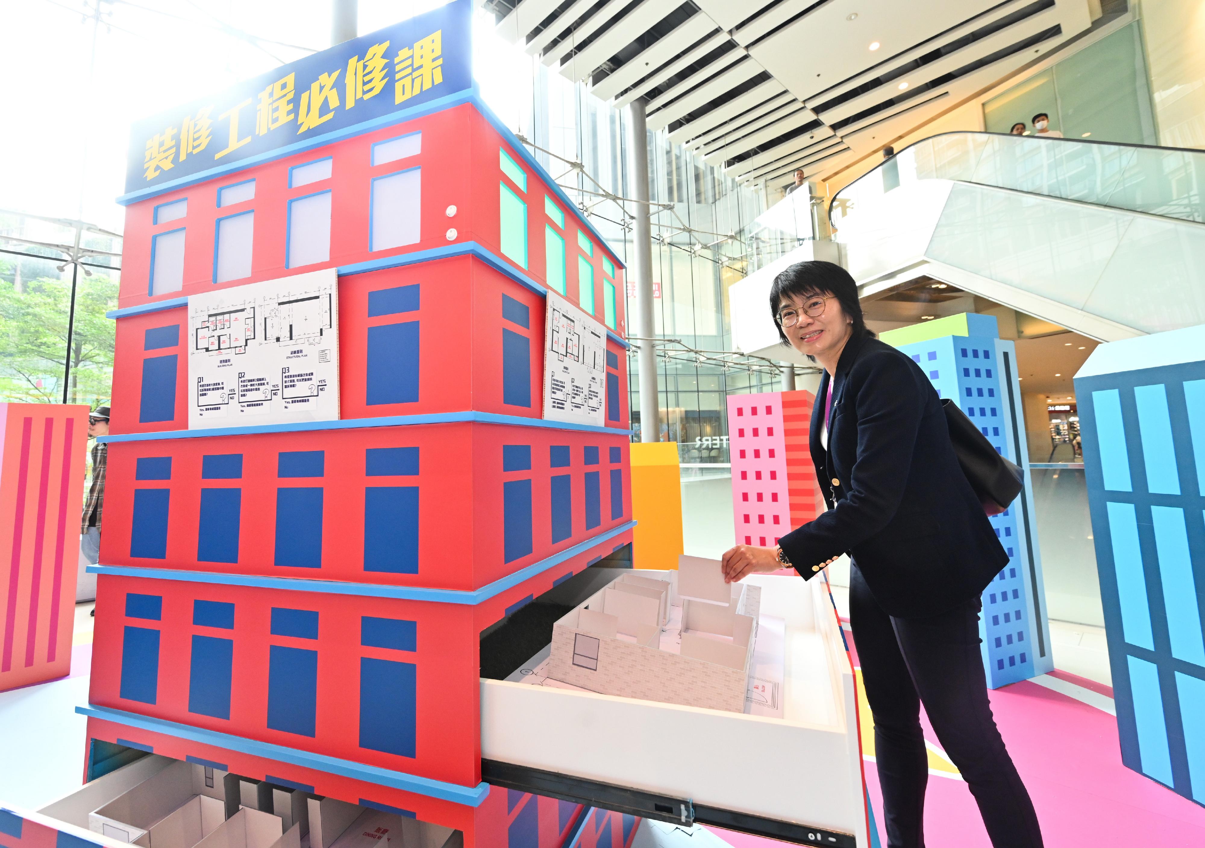 The Buildings Department launched Building Safety Week 2023 today (October 21).  Photo shows the Permanent Secretary for Development (Planning and Lands), Ms Doris Ho, trying one of the booth games at the Building Safety Carnival after the opening ceremony of Building Safety Week 2023.