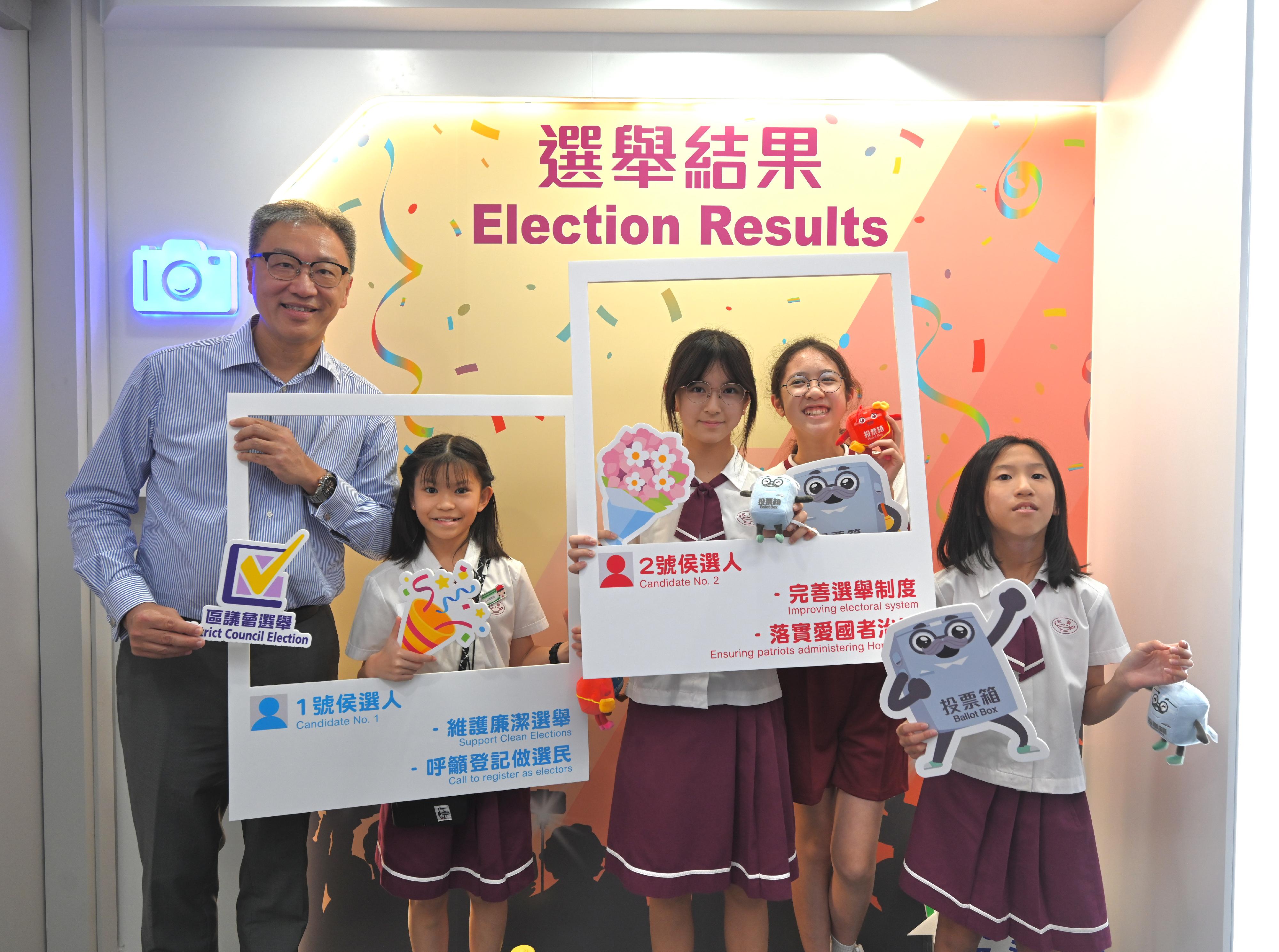 The brand new Electoral Information Centre of the Registration and Electoral Office today (October 24) officially came into operation with a new look at the new site located at the Treasury Building, Cheung Sha Wan. Photo shows the Chairman of the Electoral Affairs Commission, Mr Justice Lok, and the students at the photo area.