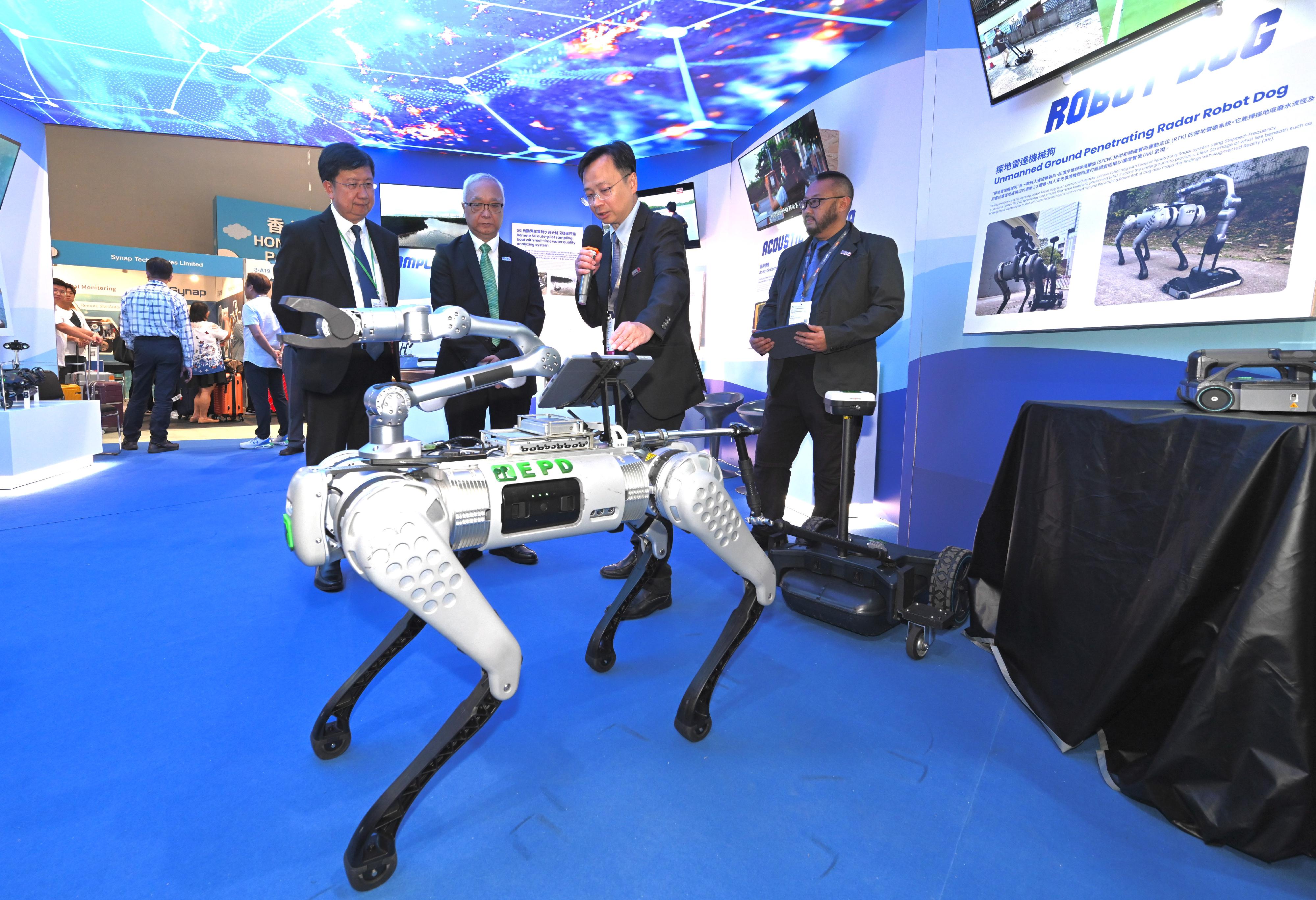 The Secretary for Environment and Ecology, Mr Tse Chin-wan (second left), visits the physical exhibition held by the Environment and Ecology Bureau at the 18th Eco Expo Asia today (October 26) and is briefed on the operation of an unmanned ground penetrating radar robot dog at the "GreenTech" zone.