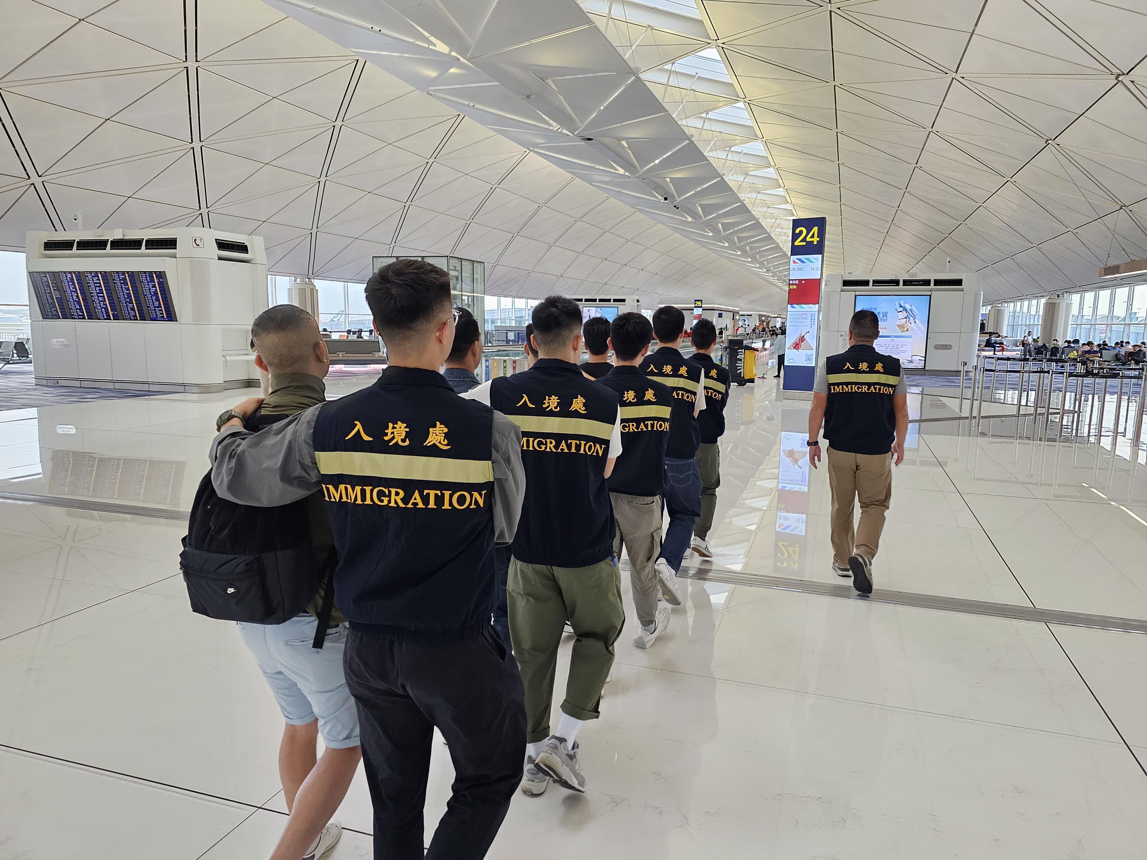 The Immigration Department (ImmD) carried out a repatriation operation today (October 31). A total of 21 Vietnamese illegal immigrants were repatriated to Vietnam. Photo shows removees being escorted by ImmD officers to depart from Hong Kong.