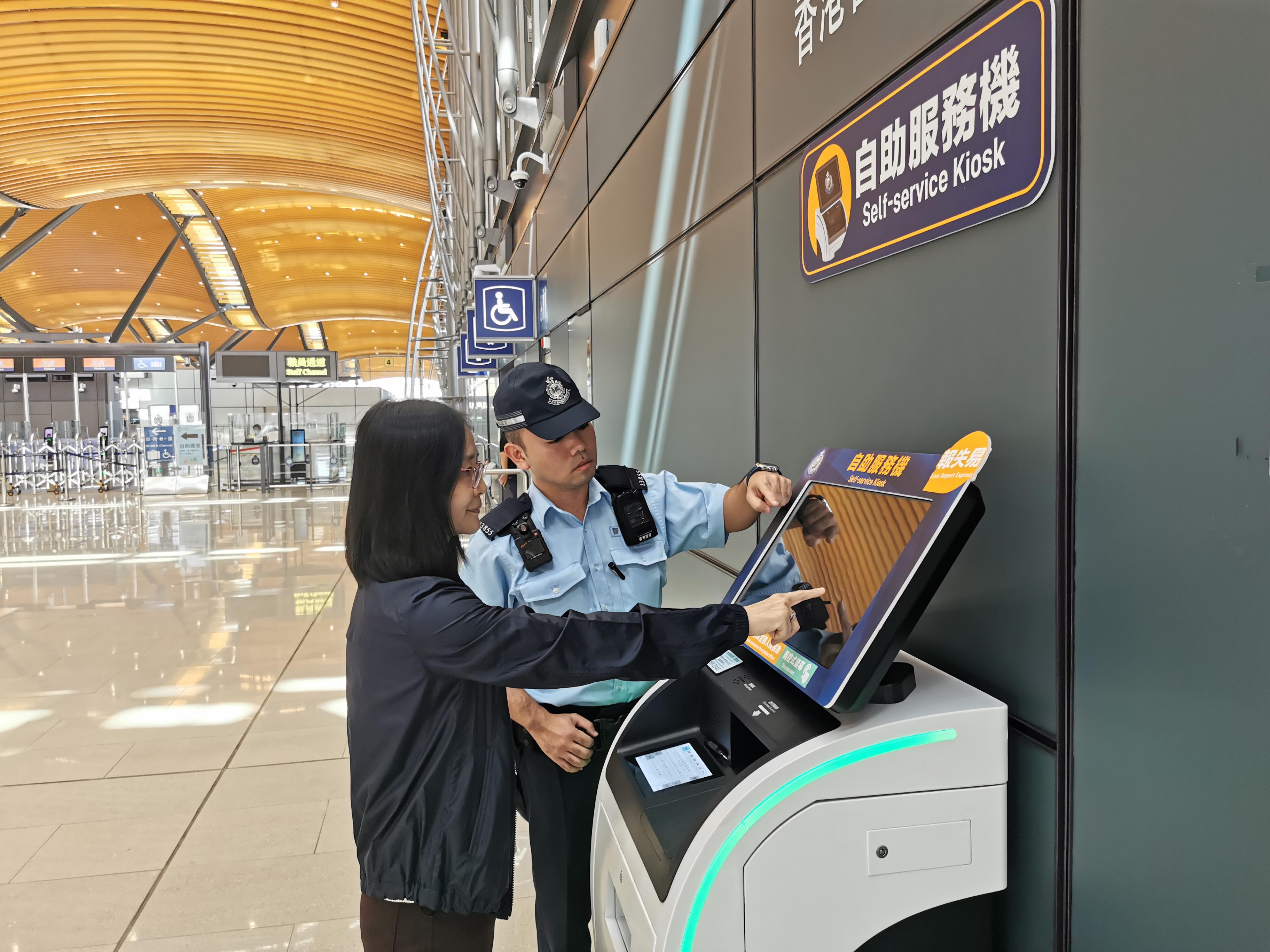 The Self-service Kiosk (SSK) installed by the Hong Kong Police Force outside the police reporting centre in the Passenger Clearance Building at the Hong Kong-Zhuhai-Macao Bridge Hong Kong Port commenced service today (November 1). Photo shows a police officer introducing the electronic reporting service to a tourist.
