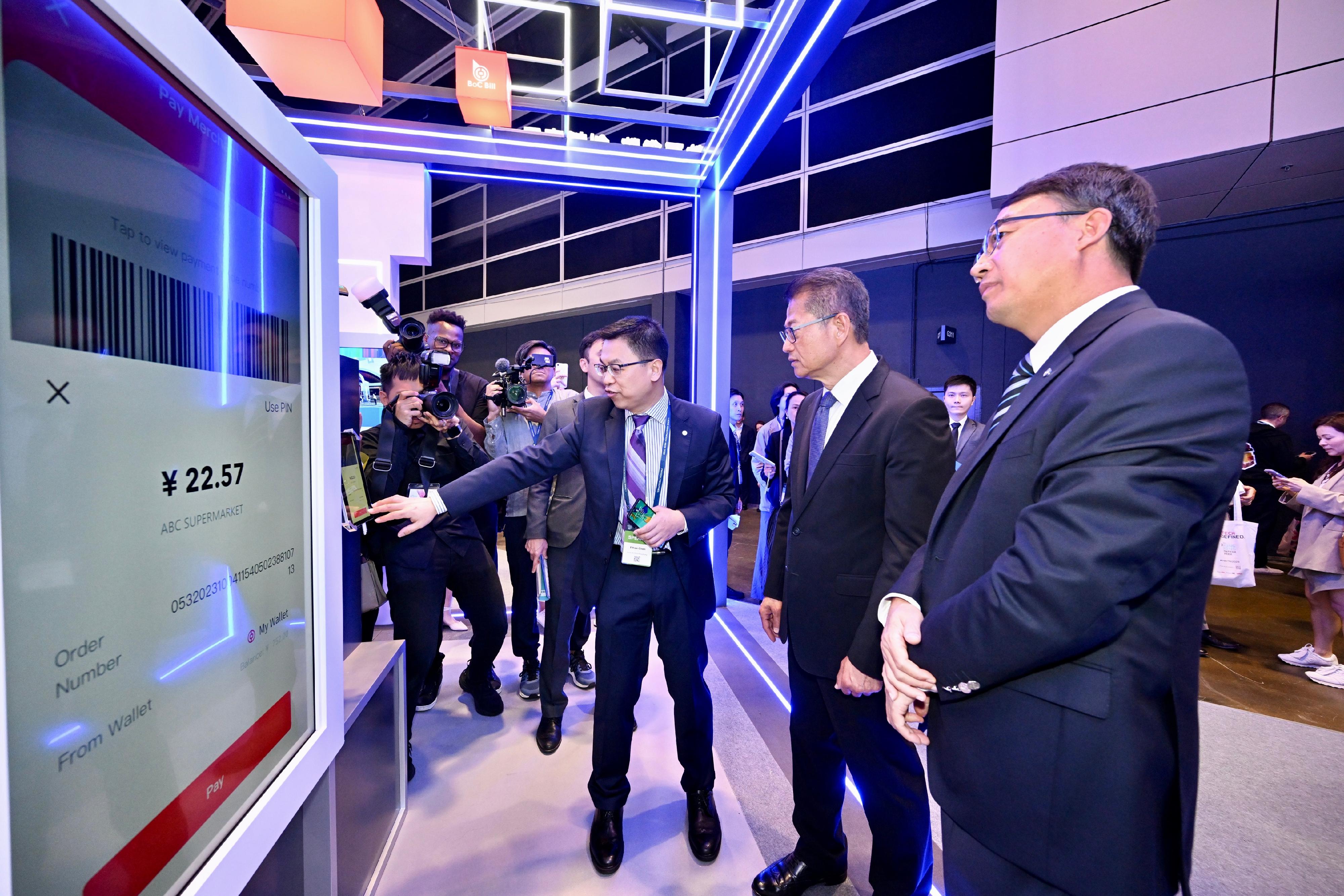 The Financial Secretary, Mr Paul Chan, attended Hong Kong FinTech Week 2023 today (November 2). Photo shows Mr Chan (second right) touring an exhibition booth.


