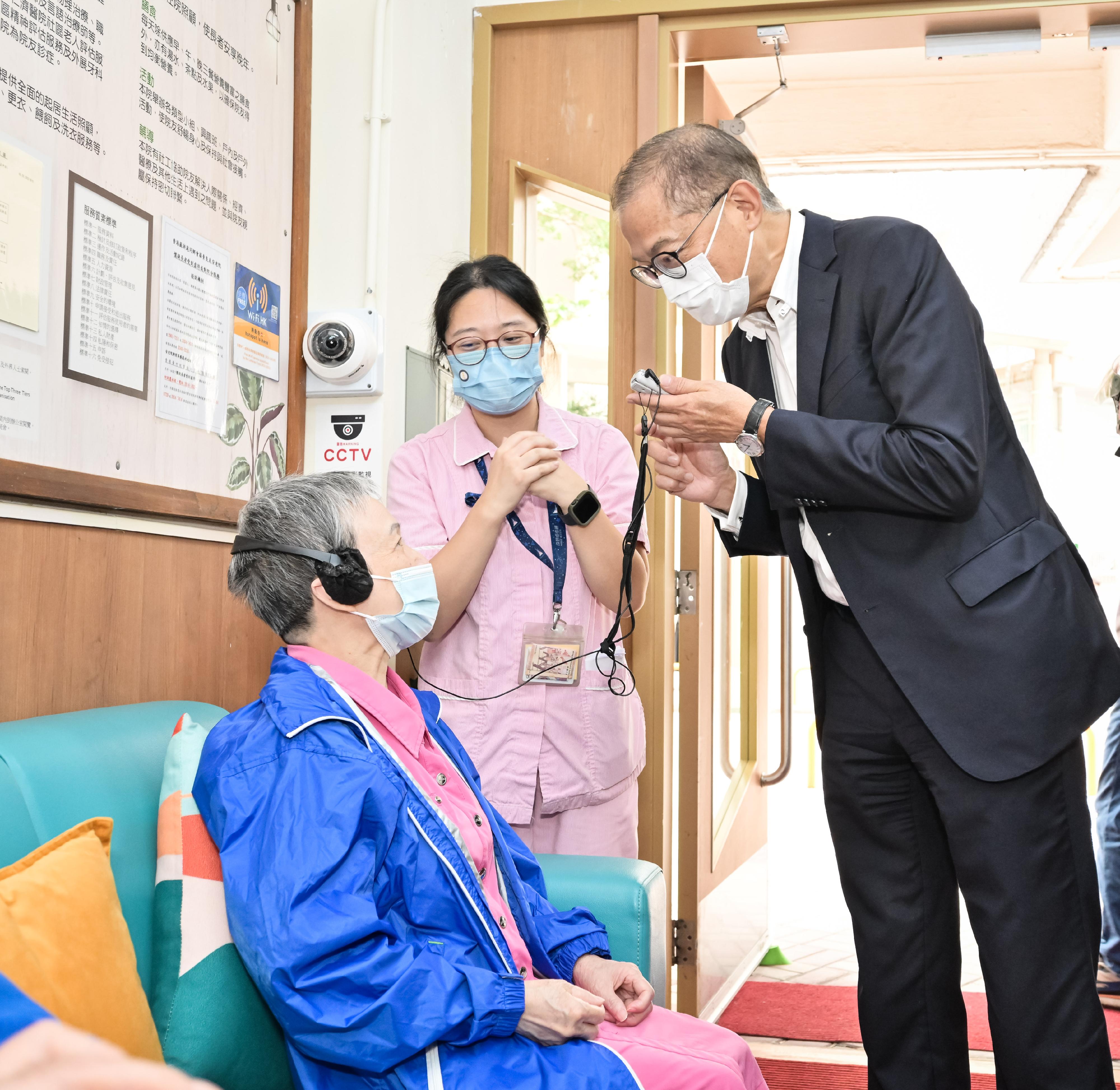 The Secretary for Health, Professor Lo Chung-mau, visited a residential care home for the elderly (RCHE) in Kwai Tsing District this afternoon (November 3) to get a better grasp of the basic dental care services provided to residents of RCHEs by outreach dental teams. Photo shows Professor Lo (first right) chatting with a resident of the RCHE to listen to her views on the services.