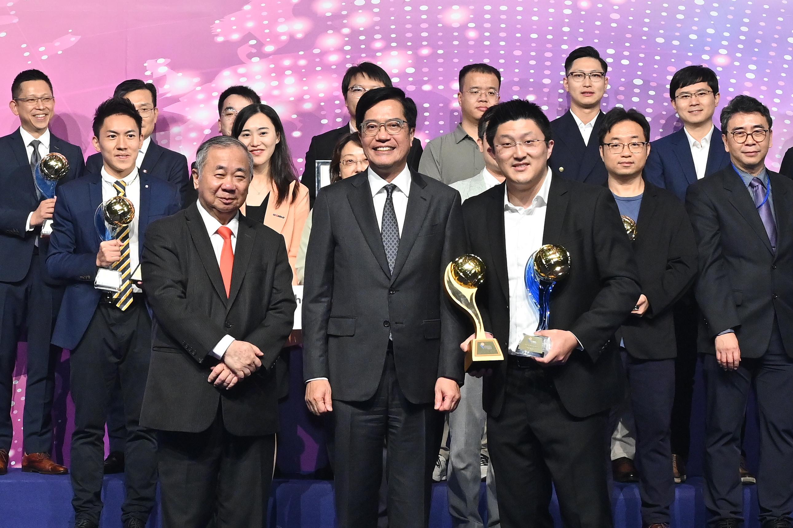 The Deputy Financial Secretary, Mr Michael Wong (front row, centre), presents the Award of the Year at the Hong Kong ICT Awards 2023 Awards Presentation Ceremony to KRIP Limited this evening (November 3). The Chairman of the Hong Kong ICT Awards 2023 Grand Judging Panel, the President of City University of Hong Kong, Professor Freddy Boey (front row, left), is also present.