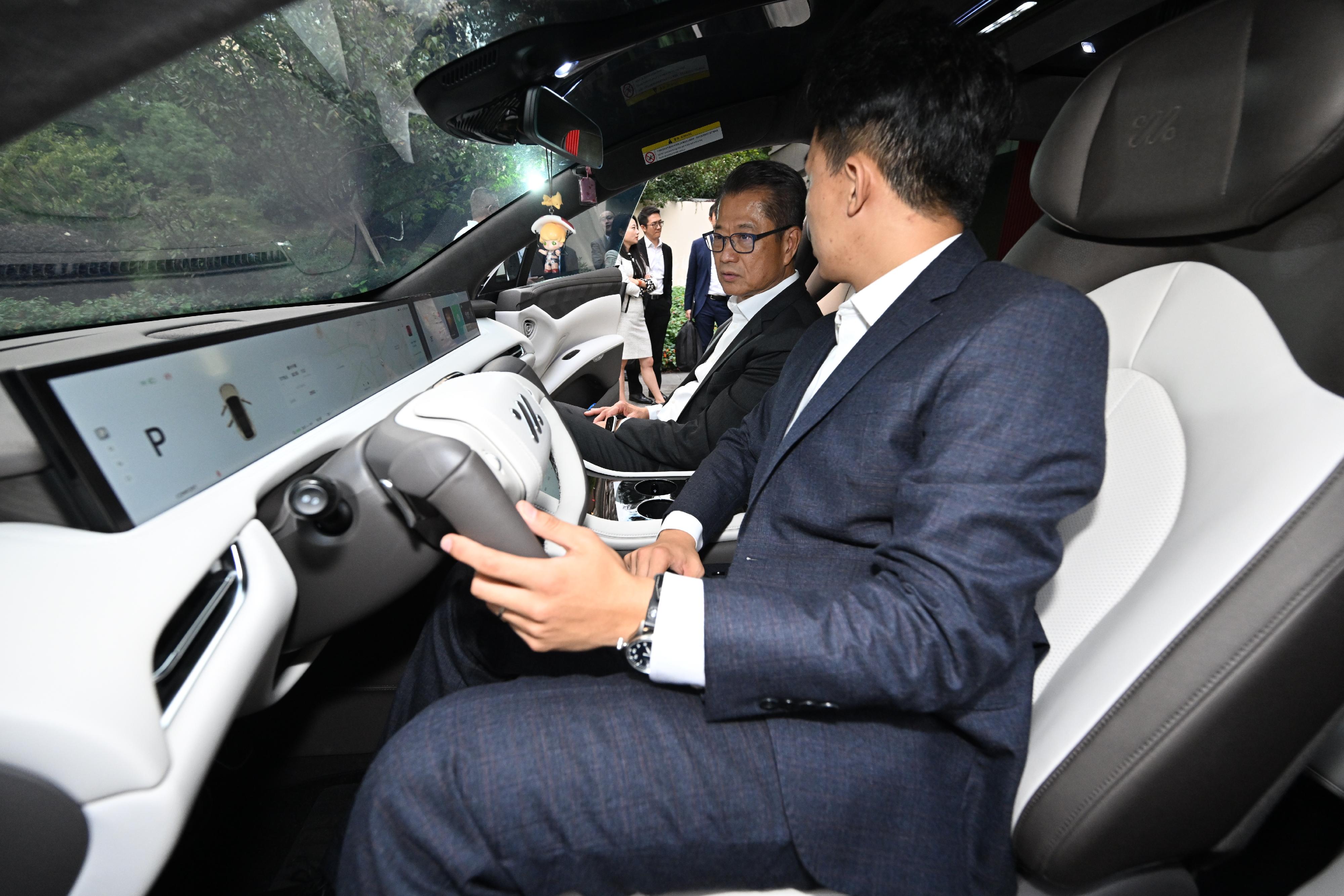 The Financial Secretary, Mr Paul Chan, visited SAIC Group in Shanghai today (November 4).  Photo shows Mr Chan (second right) taking a look at a vehicle developed and manufactured by the Group.