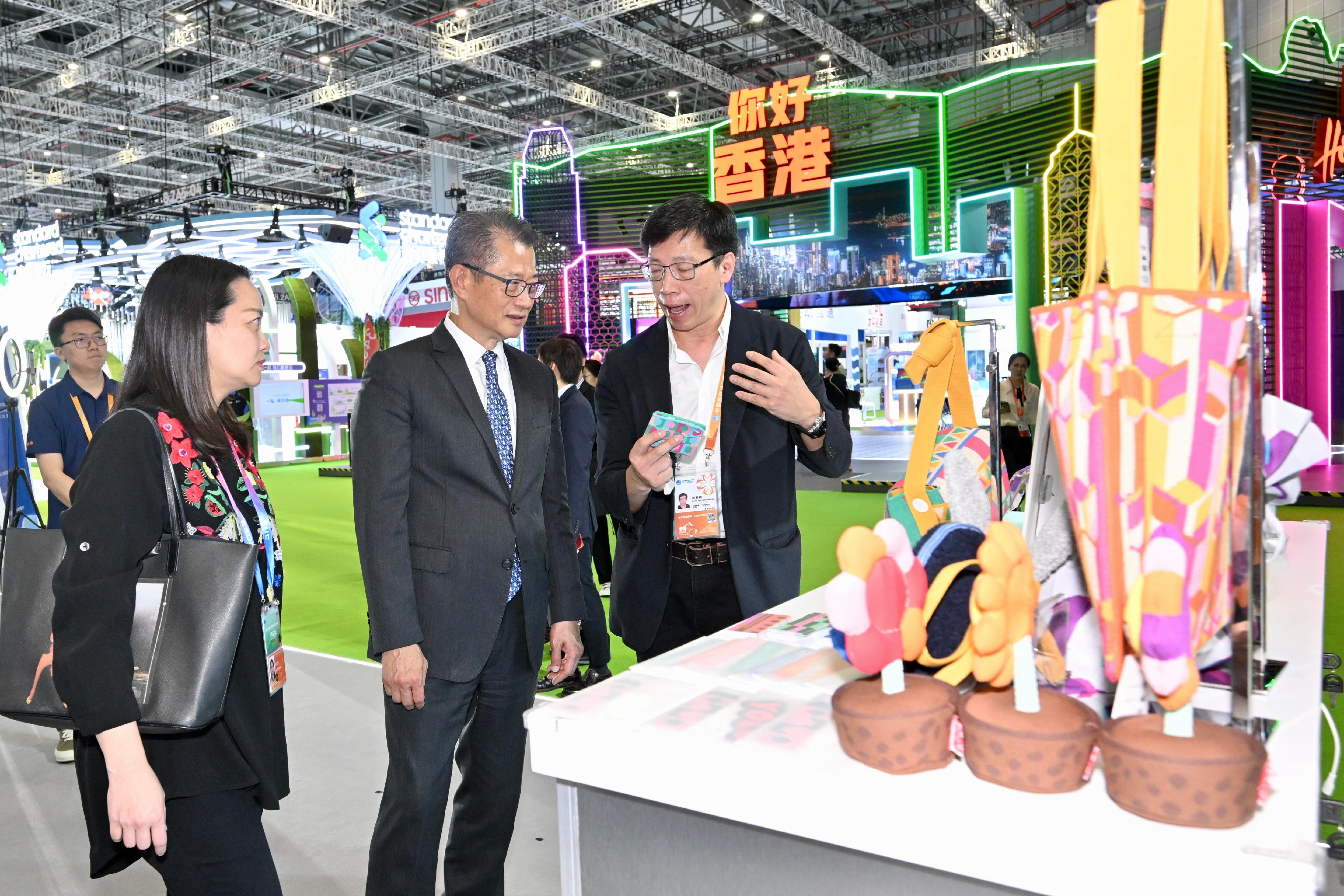財政司司長陳茂波今日（十一月五日）在上海舉行的第六屆中國國際進口博覽會到訪香港的參展商展位。圖示陳茂波（左二）聽取參展商介紹其產品。
