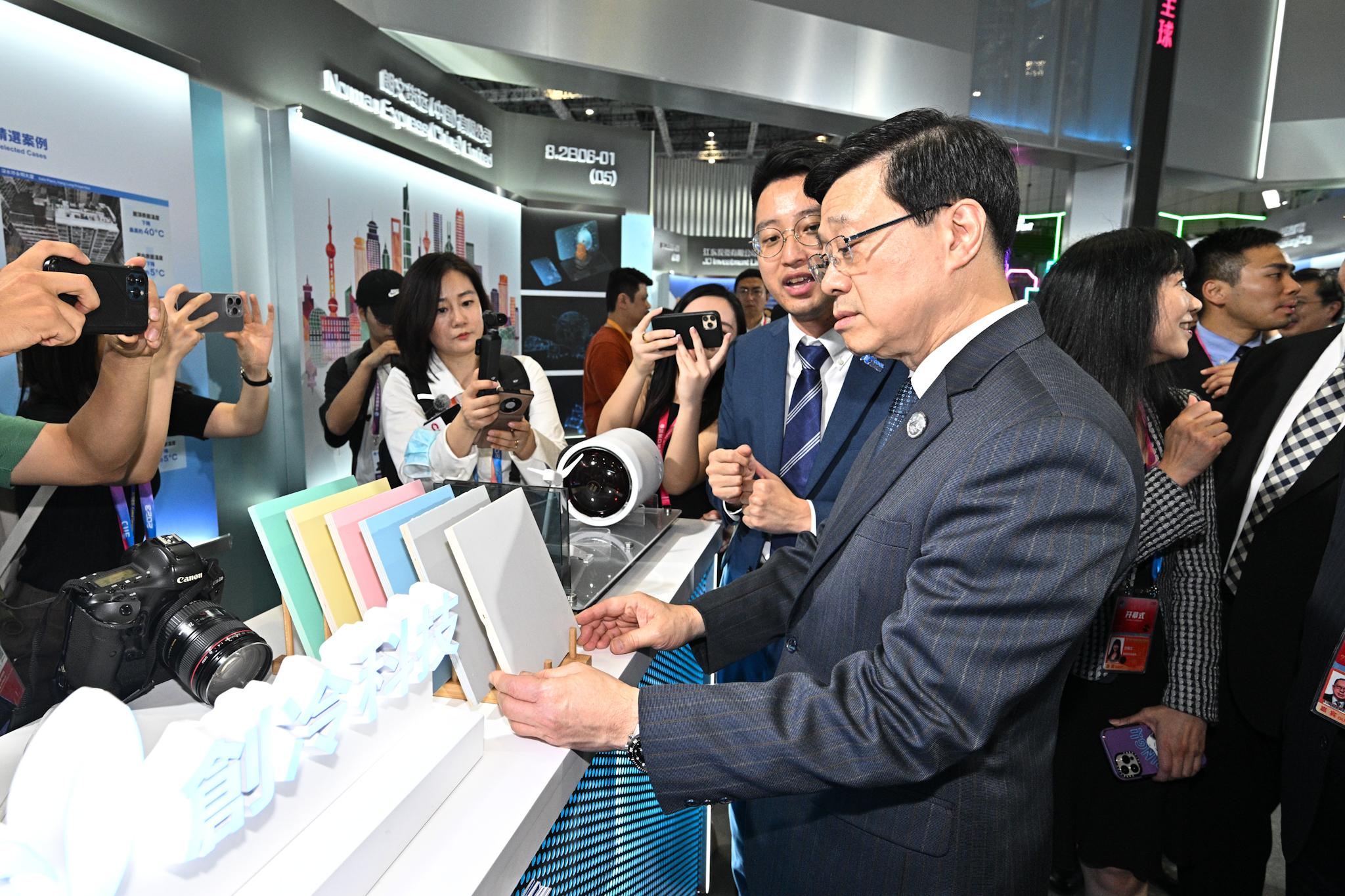 行政長官李家超今日（十一月五日）在上海參觀第六屆中國國際進口博覽會香港展示區。圖示李家超（右三）與參展商交流。